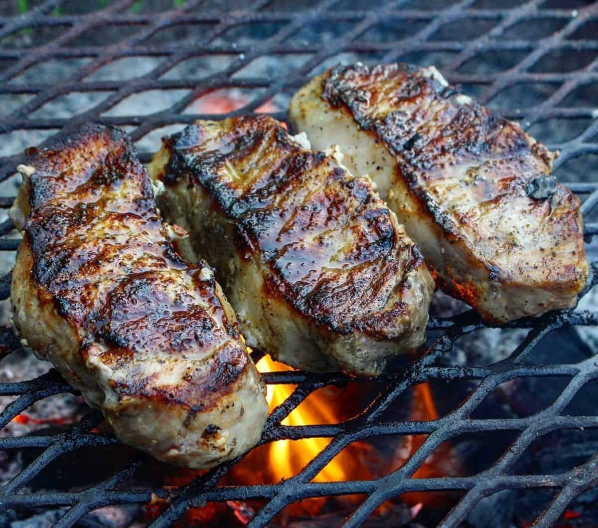 Honey sriracha pork chops on the grill over the fire. 