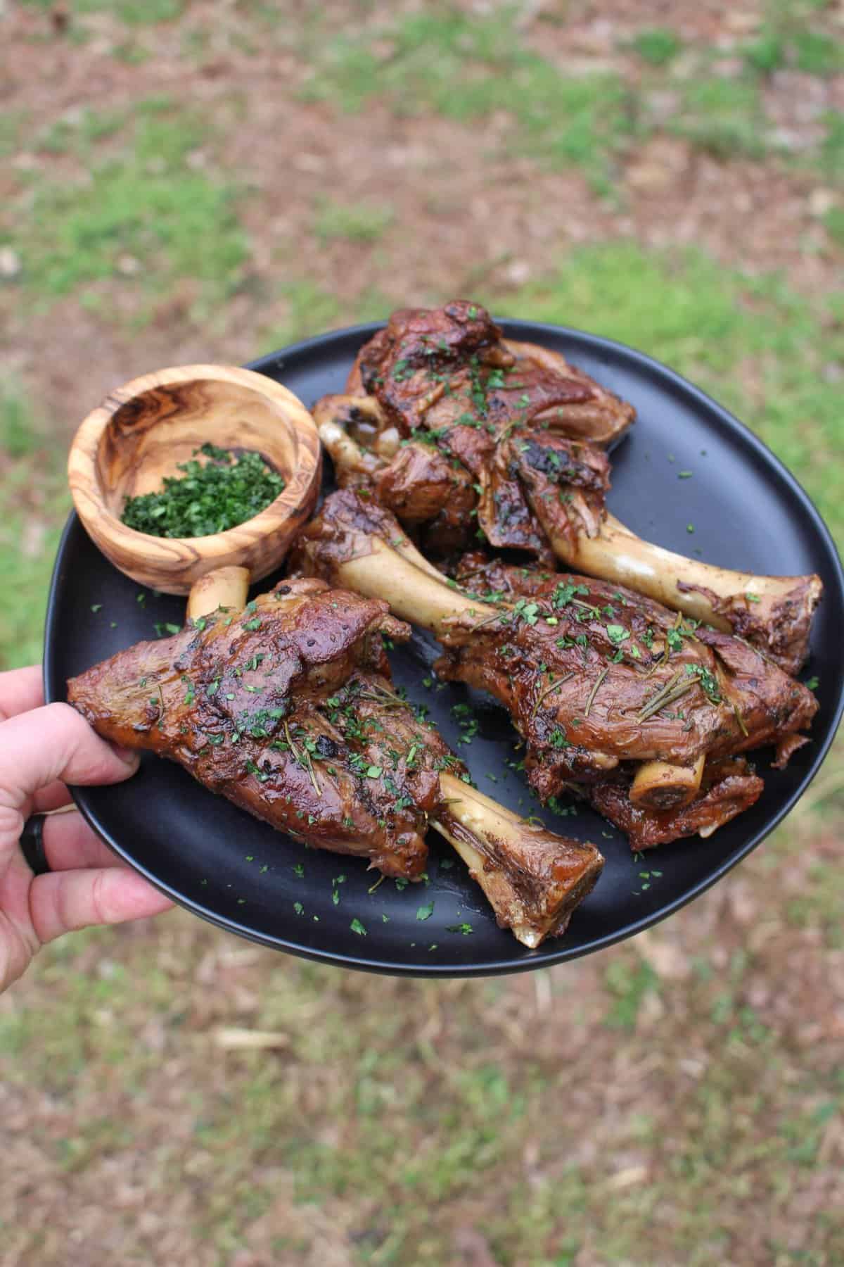 The garnished and served Beer Braised Lamb Shanks.