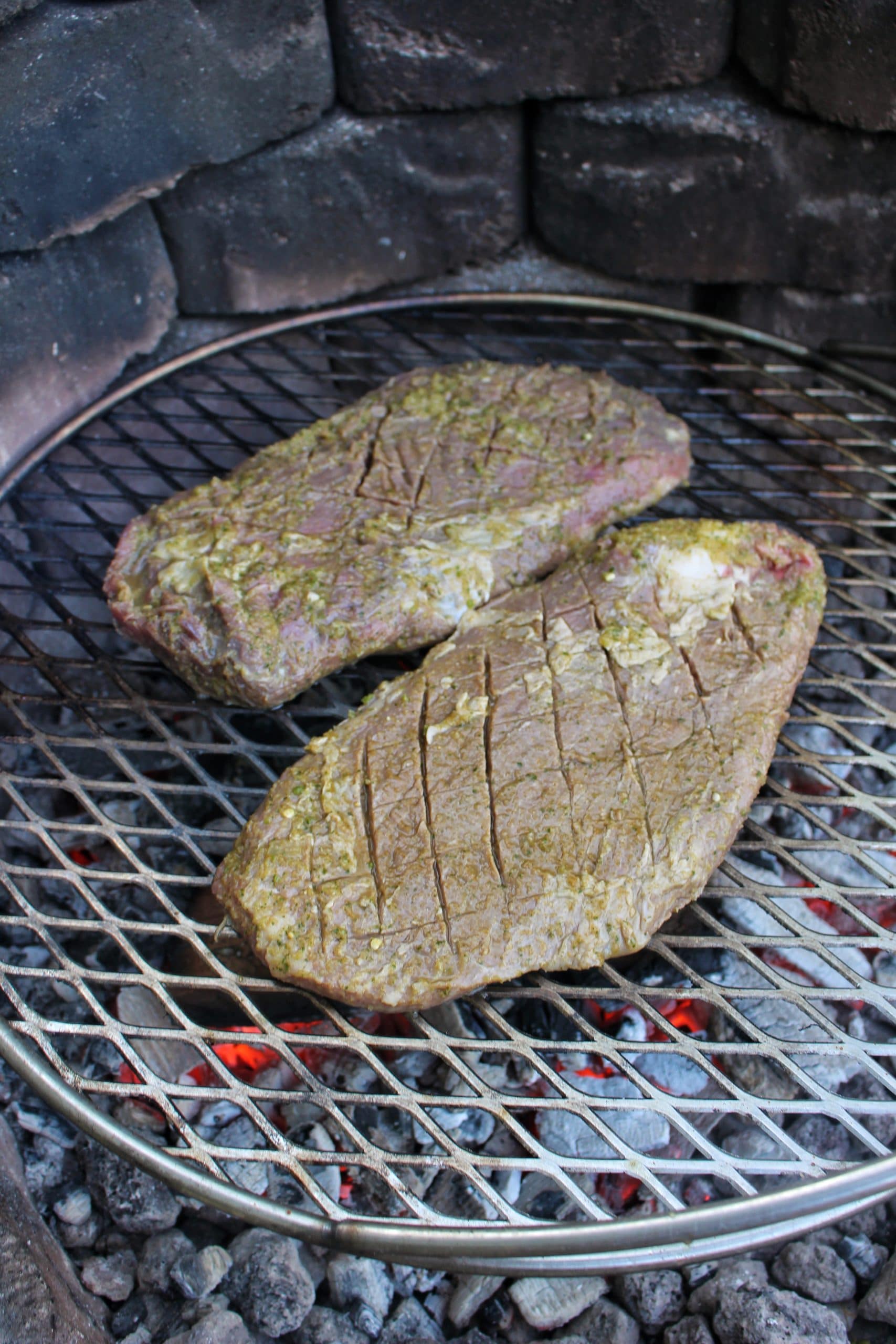 The marinaded flank steak getting started over the fire. 