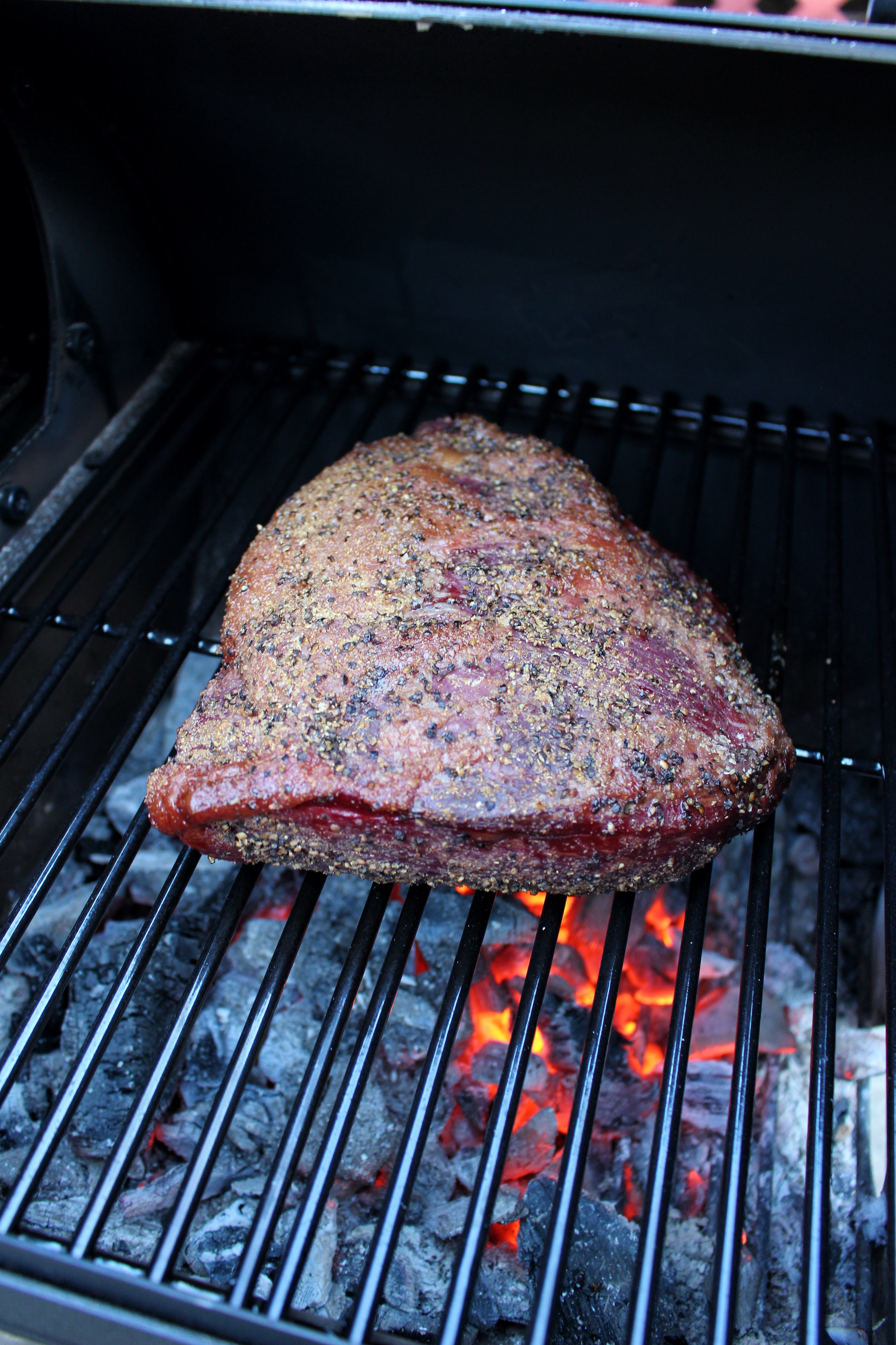 Smoked Picanha sitting over the coals so that it'll develop a nice crust.