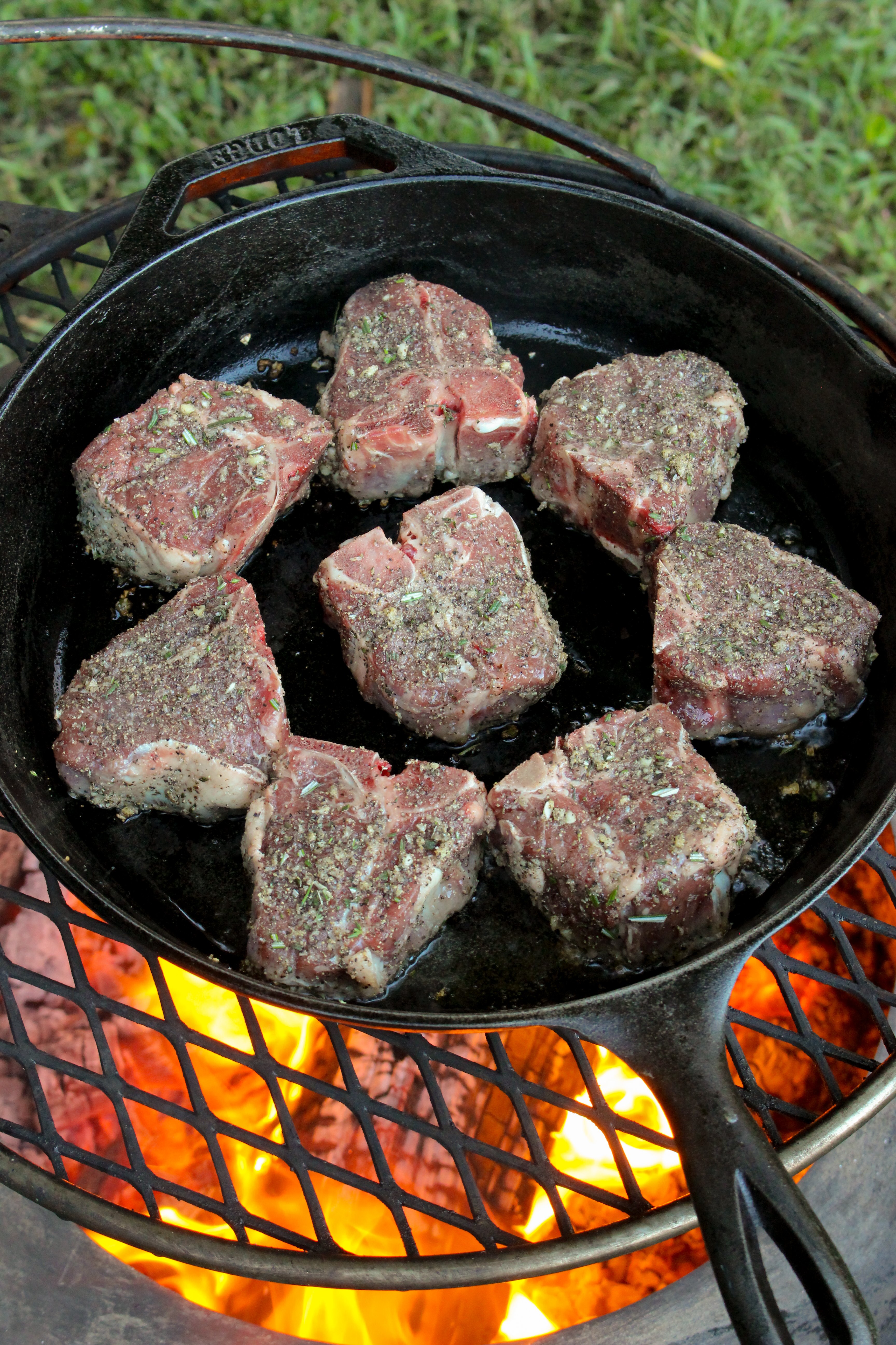 The lamb is seasoned and cooked over high heat in a pan. 