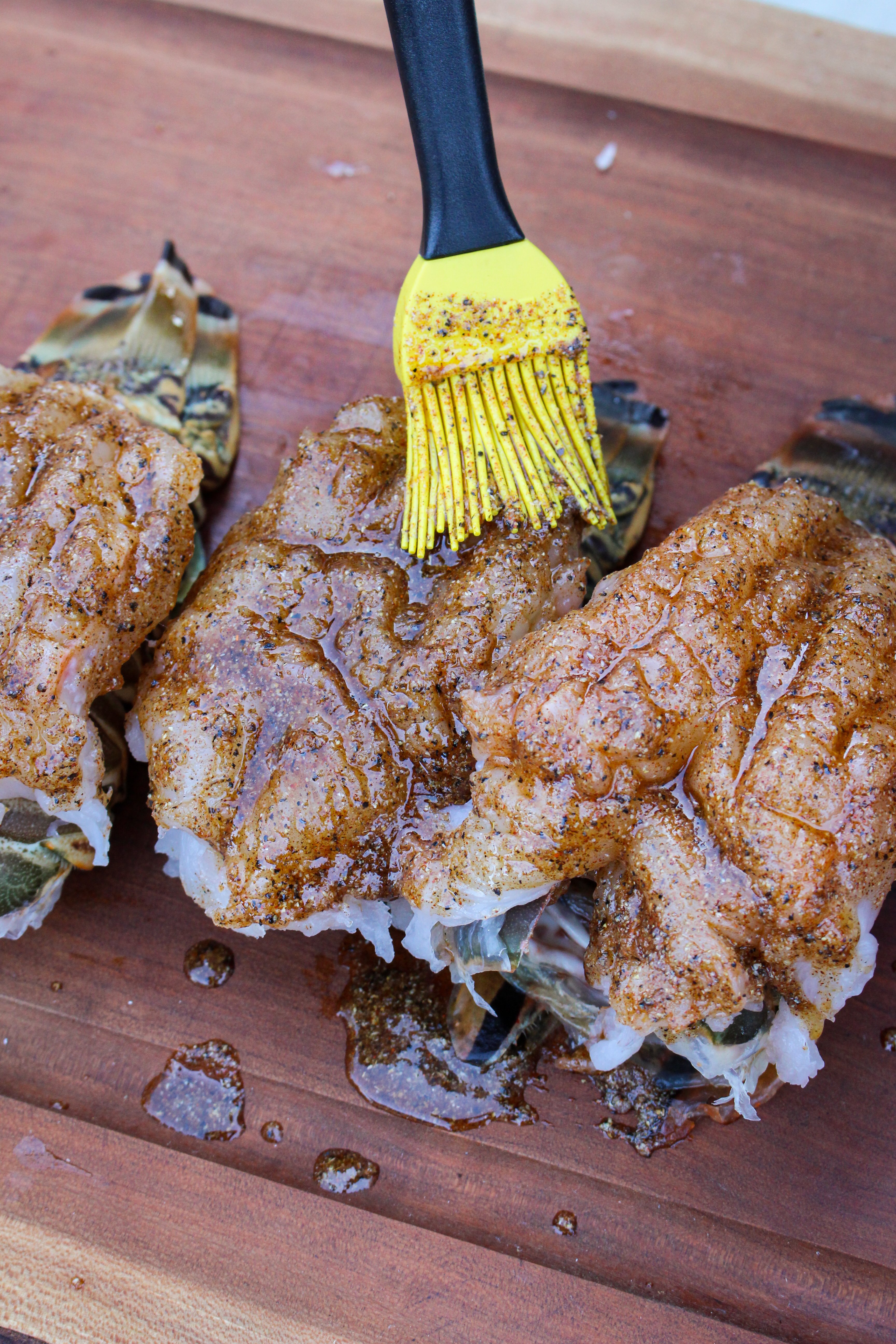 The fresh lobster tails are brushed with butter before smoking. 