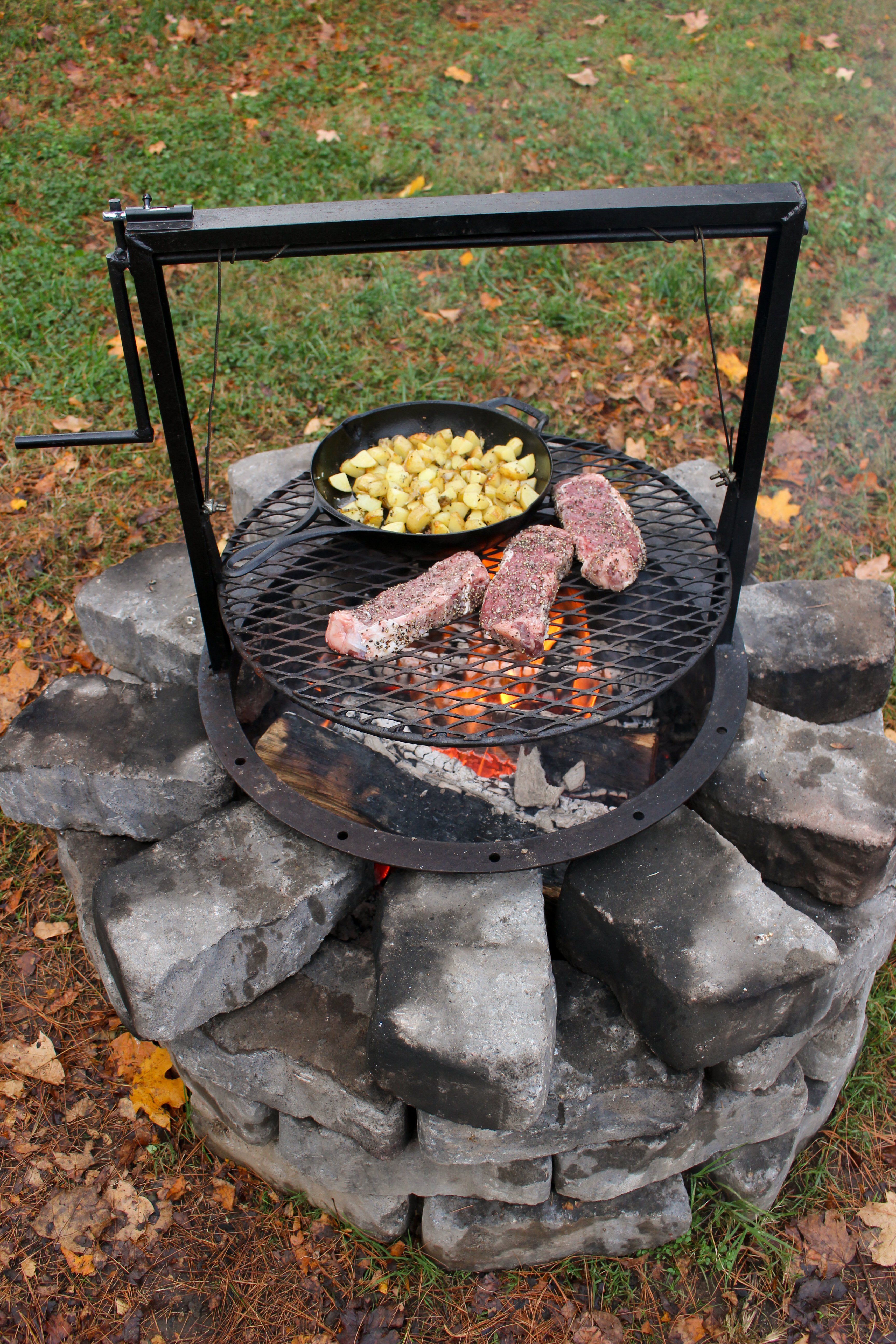 A shot of the fire pit with the dish cooking on it. 