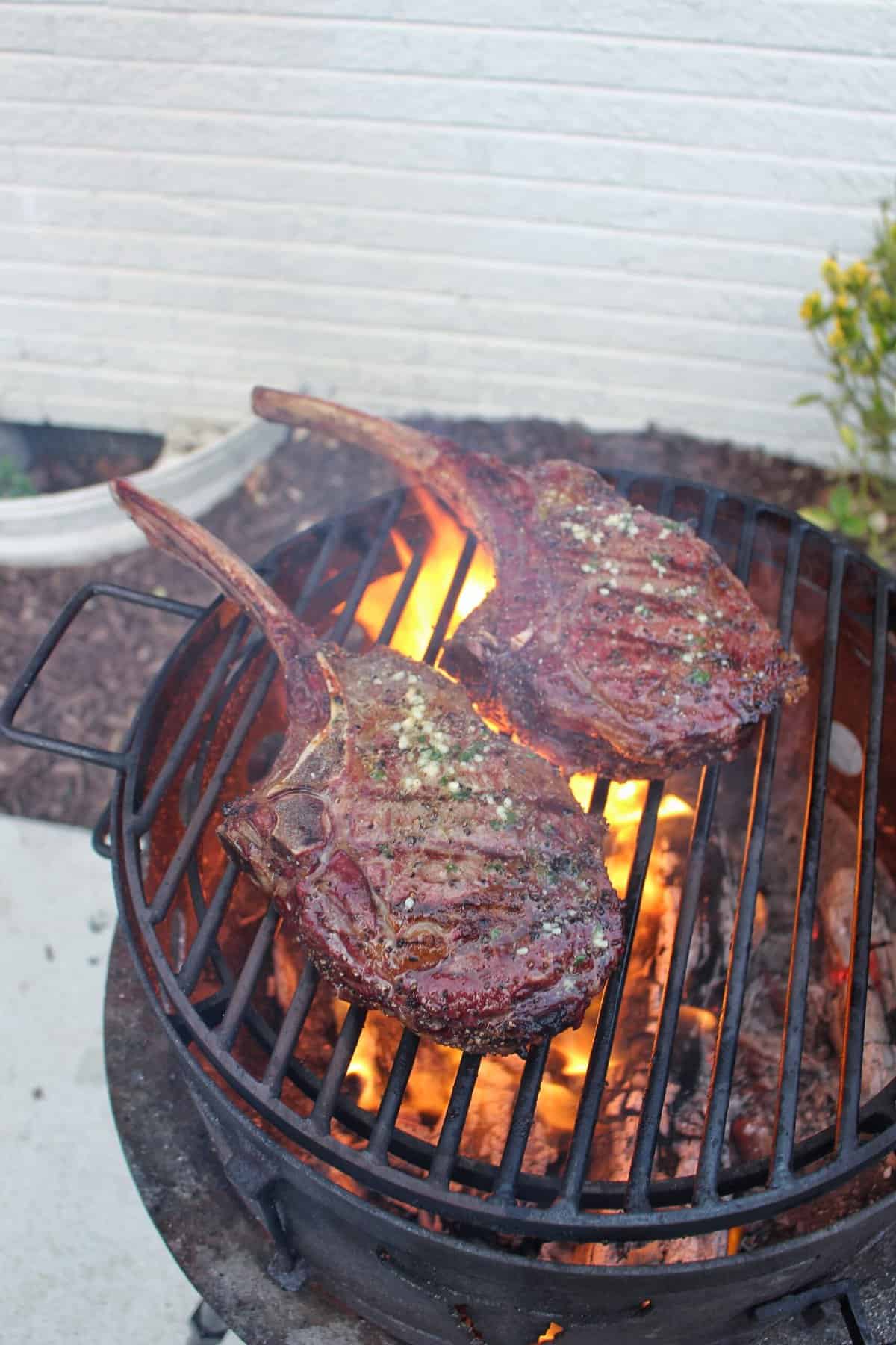 Hanging Tomahawk Steaks Over The Fire Cooking