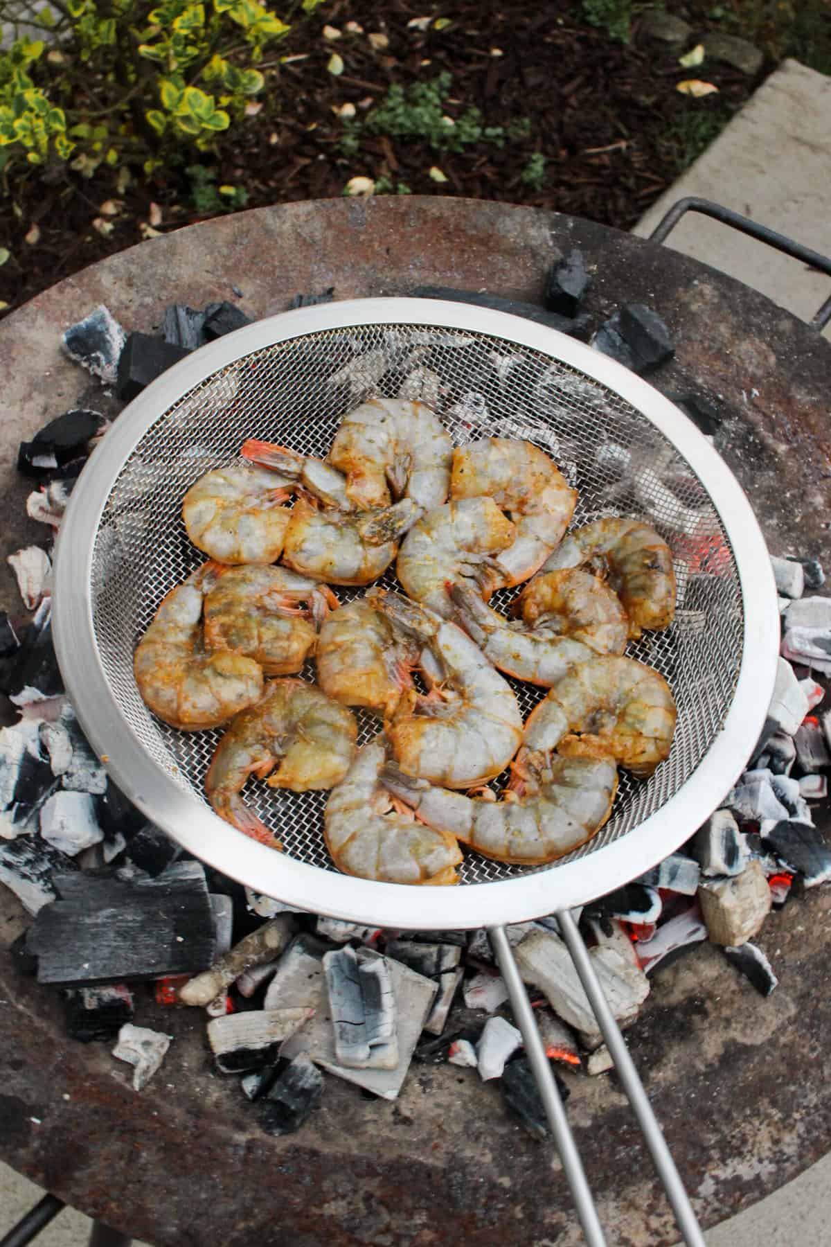 The raw shrimp getting started over the coals.