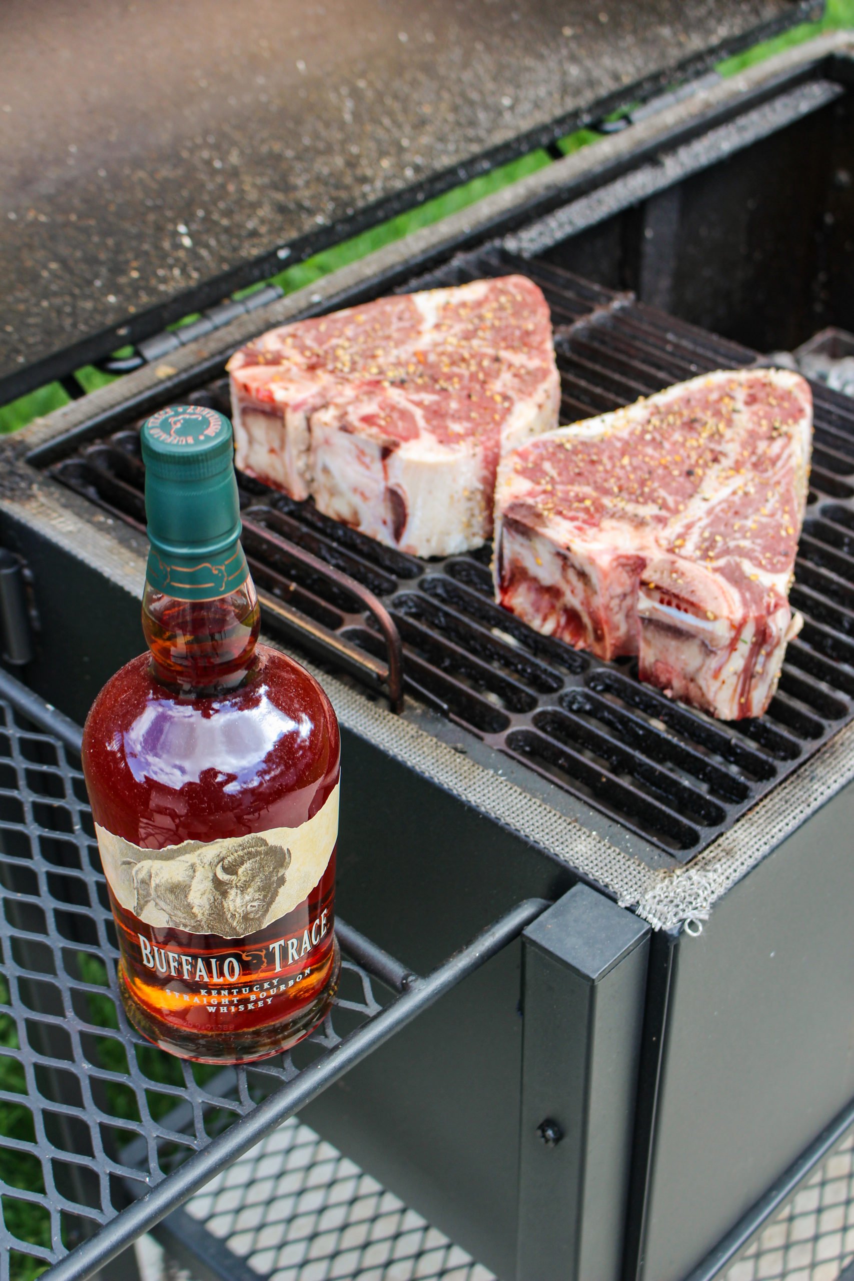 The steaks getting started on the grill with the Buffalo Trace sitting to the side. 