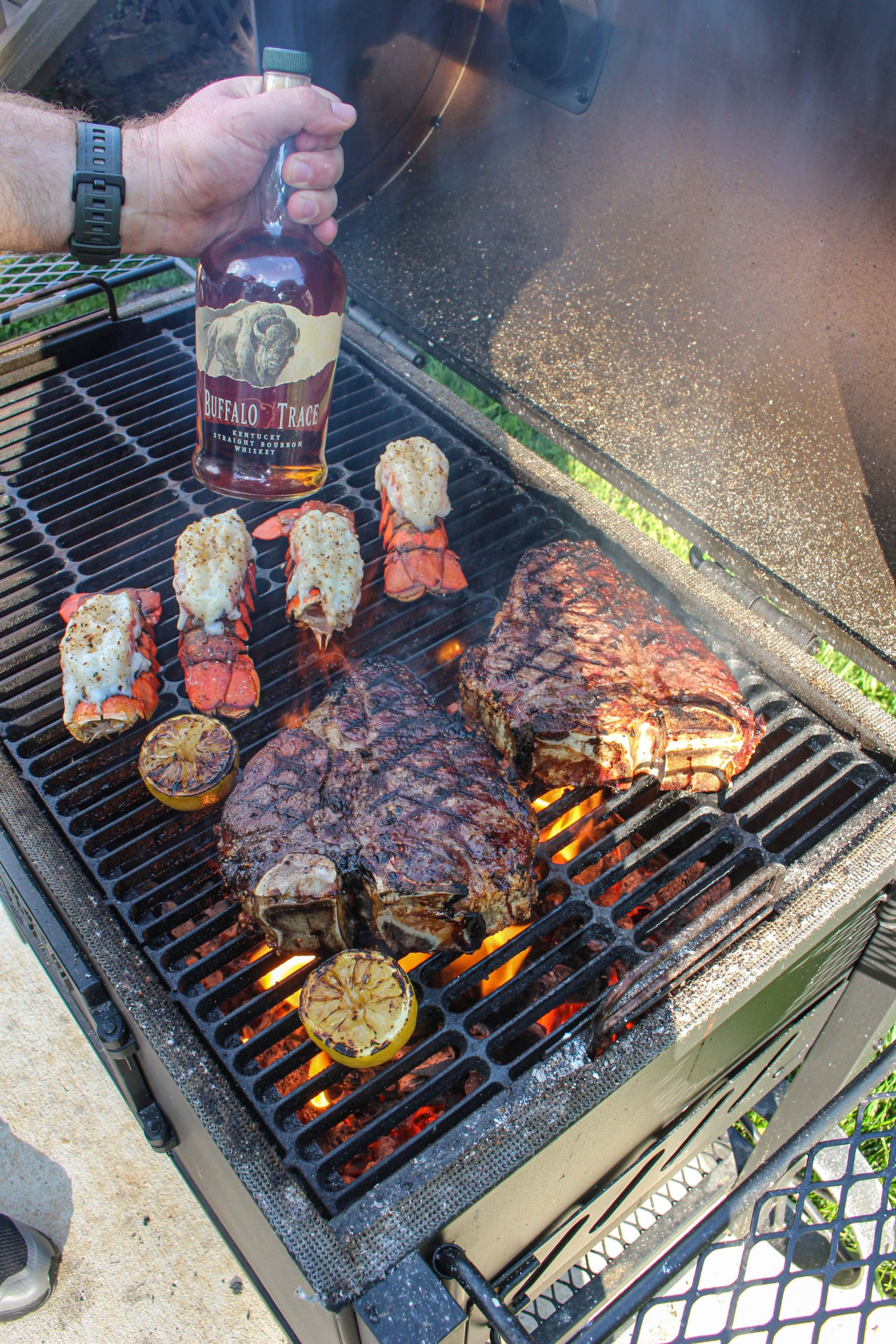 A shot of all the food on the grill with the Buffalo Trace. 