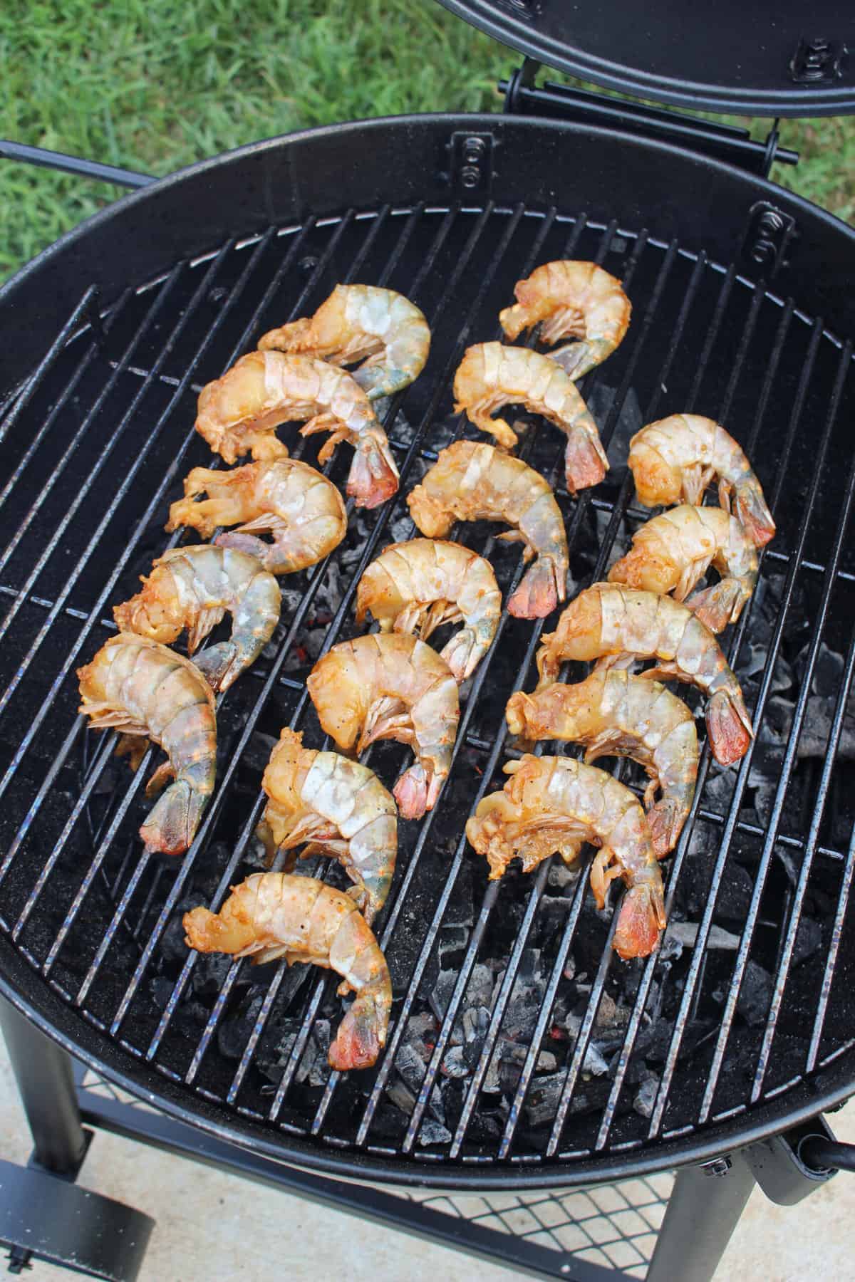 The raw shrimp getting placed on the smoker. 