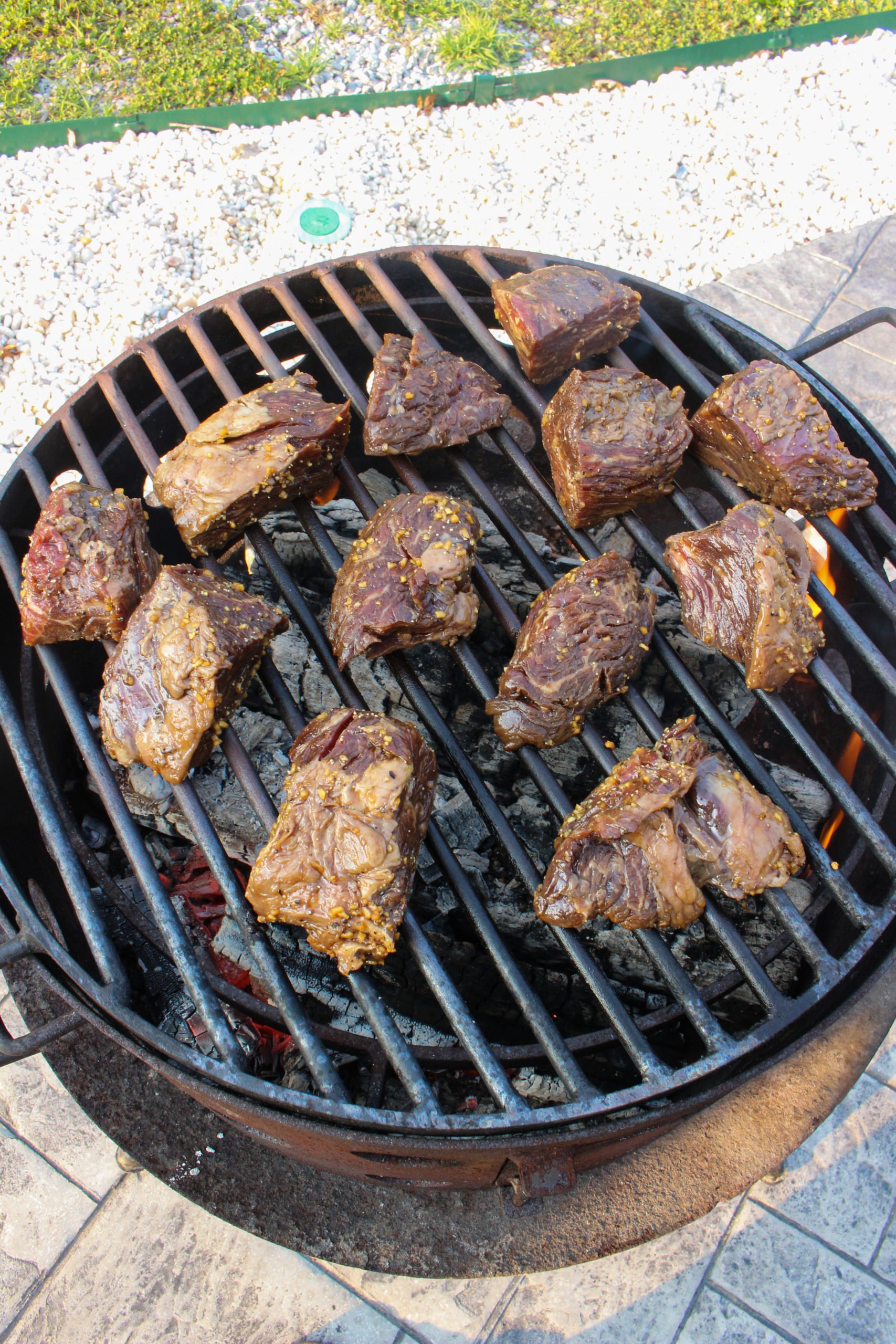 The raw steak tips getting started on the grill. 