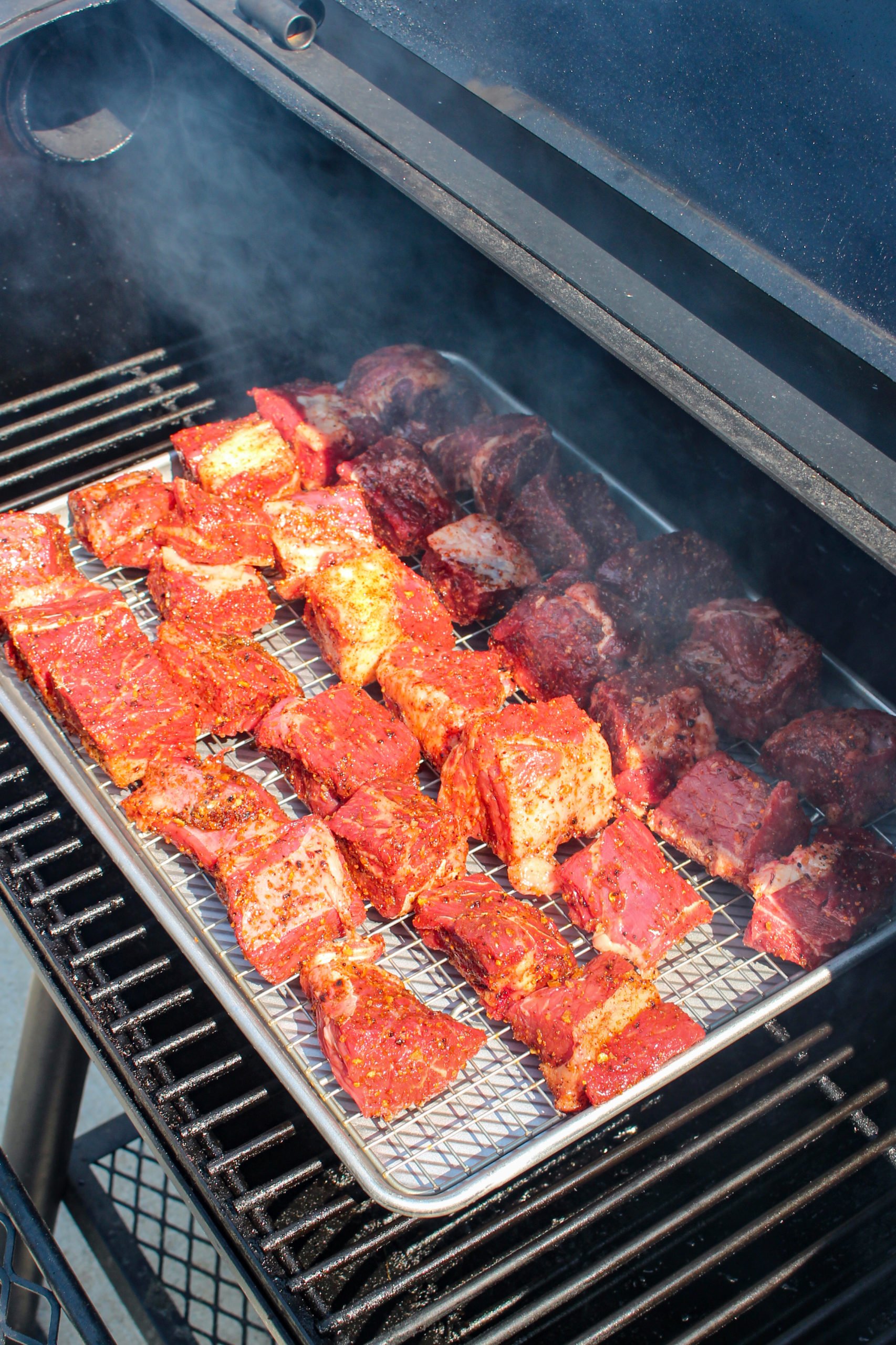 Setting the tray on the smoker.