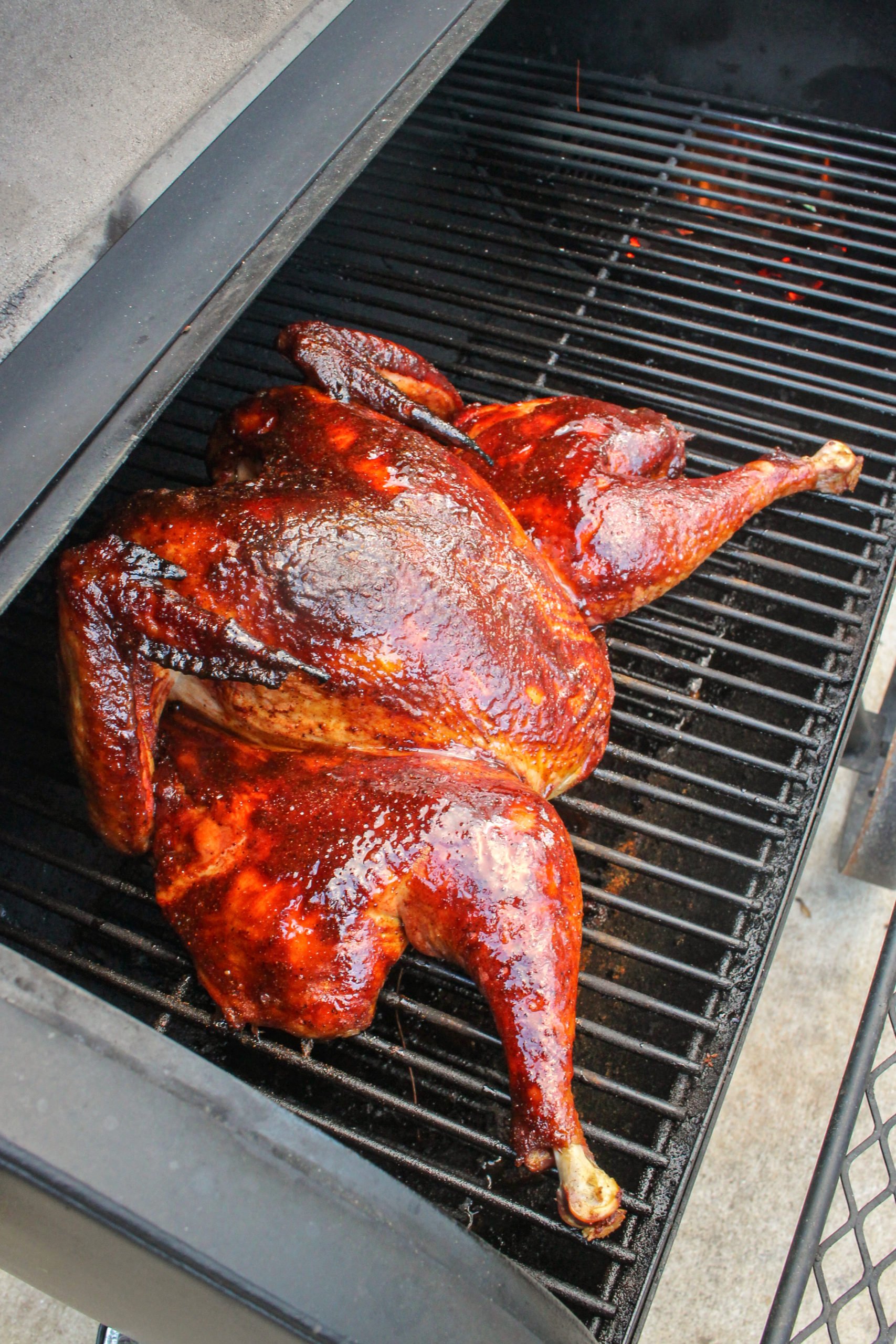 Spatchcock Turkey smoking on the grill.