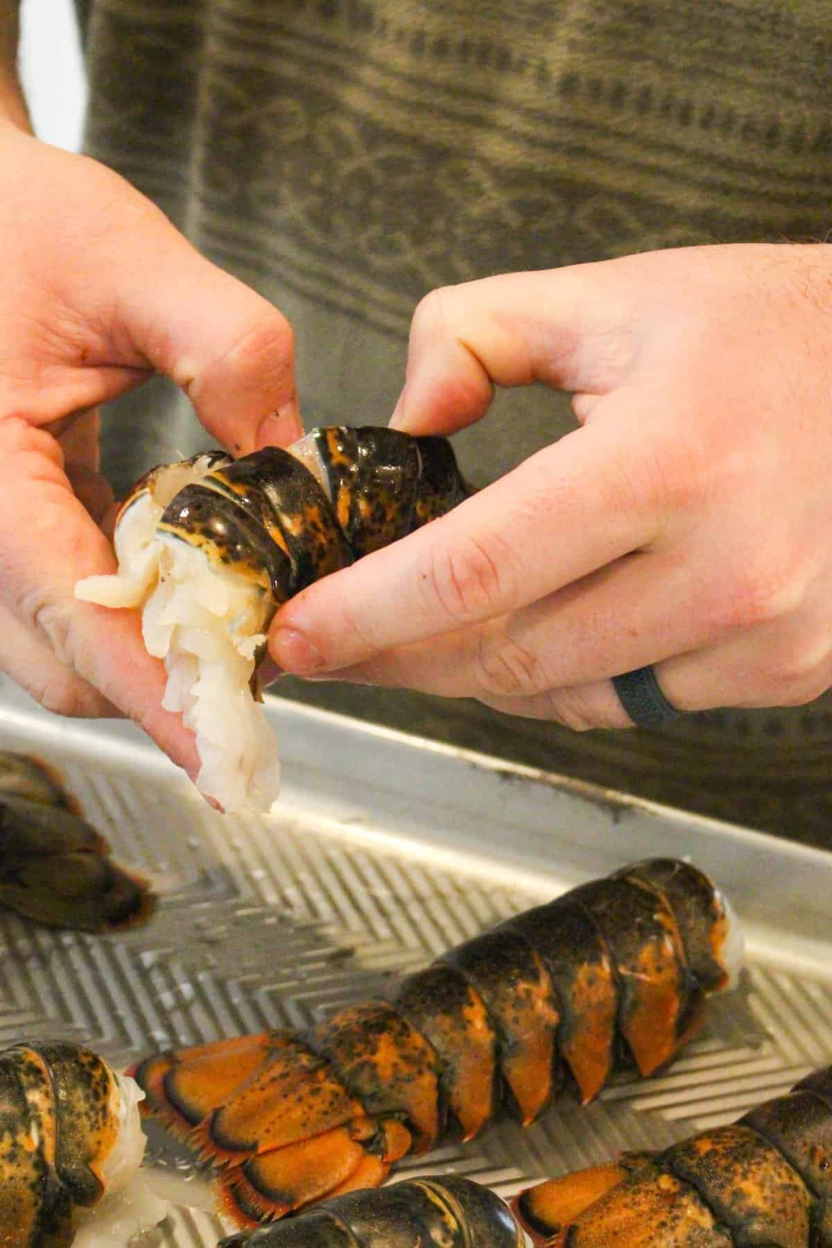 Carefully butterflying the Honey Cajun Smoked Lobster Tails.
