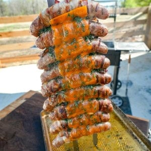 A vertical shot of finished chicken bacon ranch sausage skewers, displayed facing the camera on a cutting board
