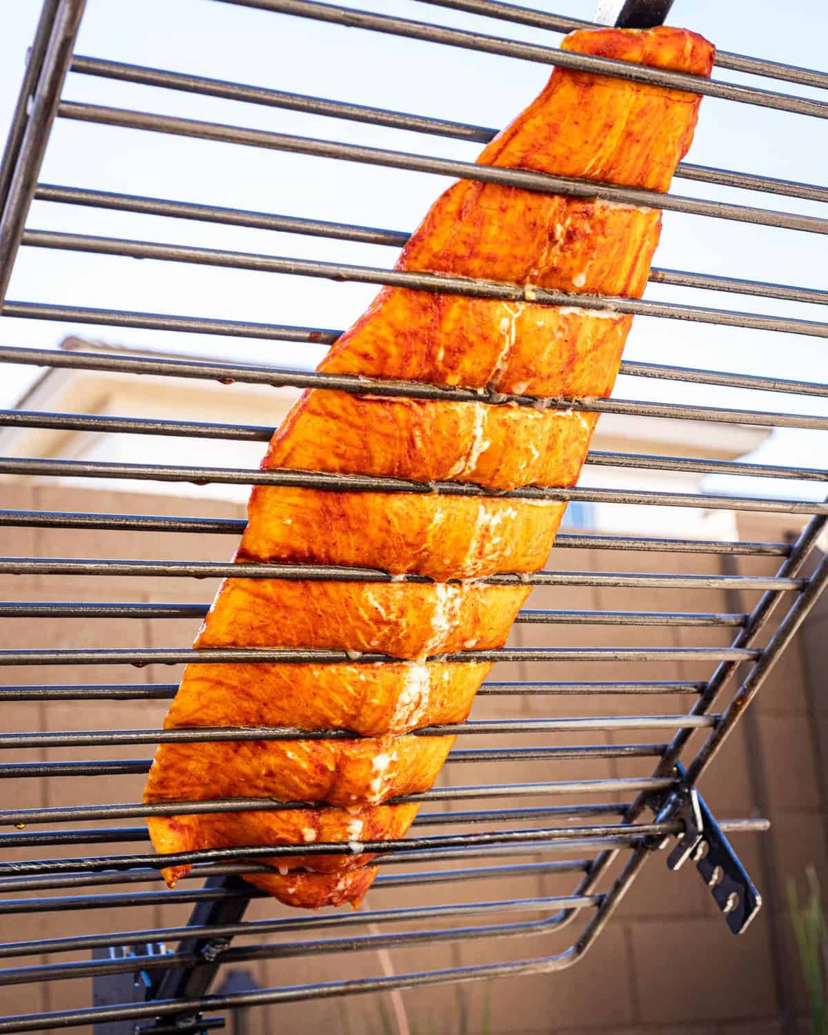 Salmon Al Pastor leaning over the fire.