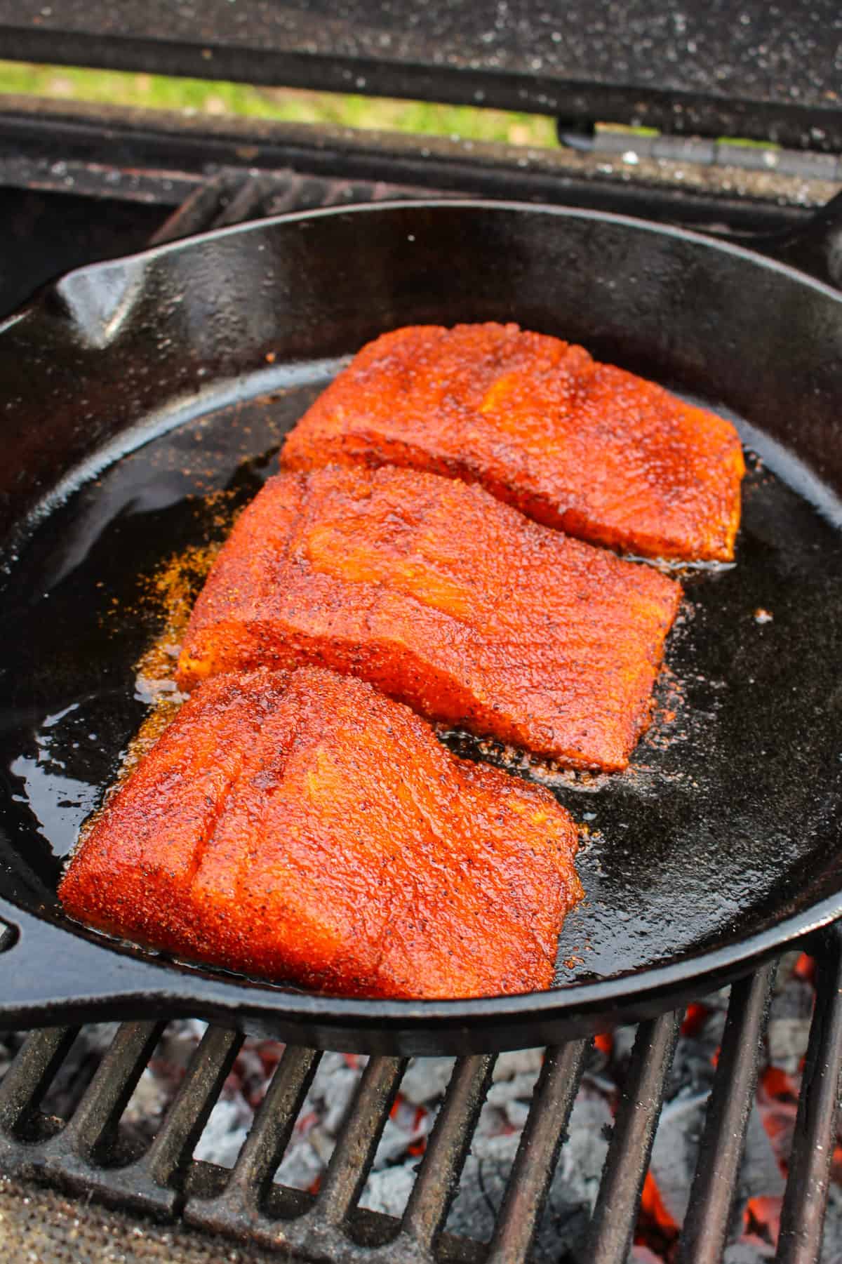 Nashville Hot Cast Iron Salmon in the skillet placed on the grill.