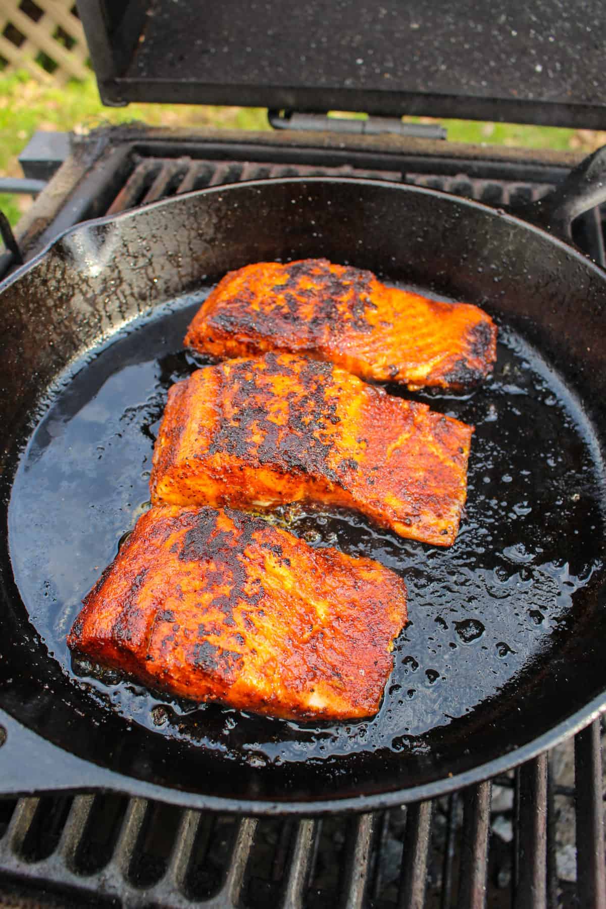 Flipping the salmon back over to top it with the Honey Garlic Butter.