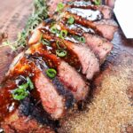 Cajun Rubbed Bourbon Street Steak sliced and topped with its sauce.