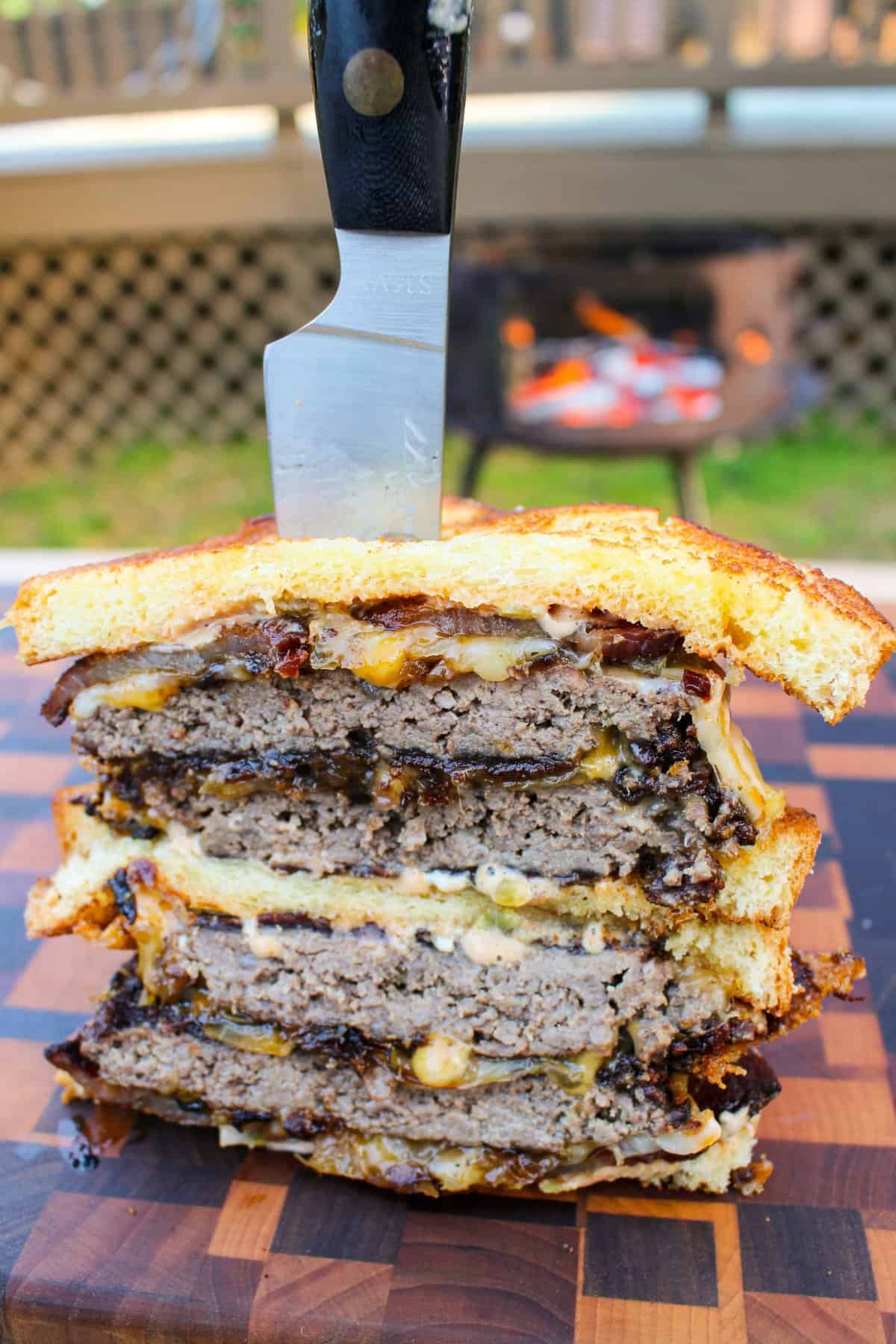 a stack of patty melt halves with a knife stuck in the middle