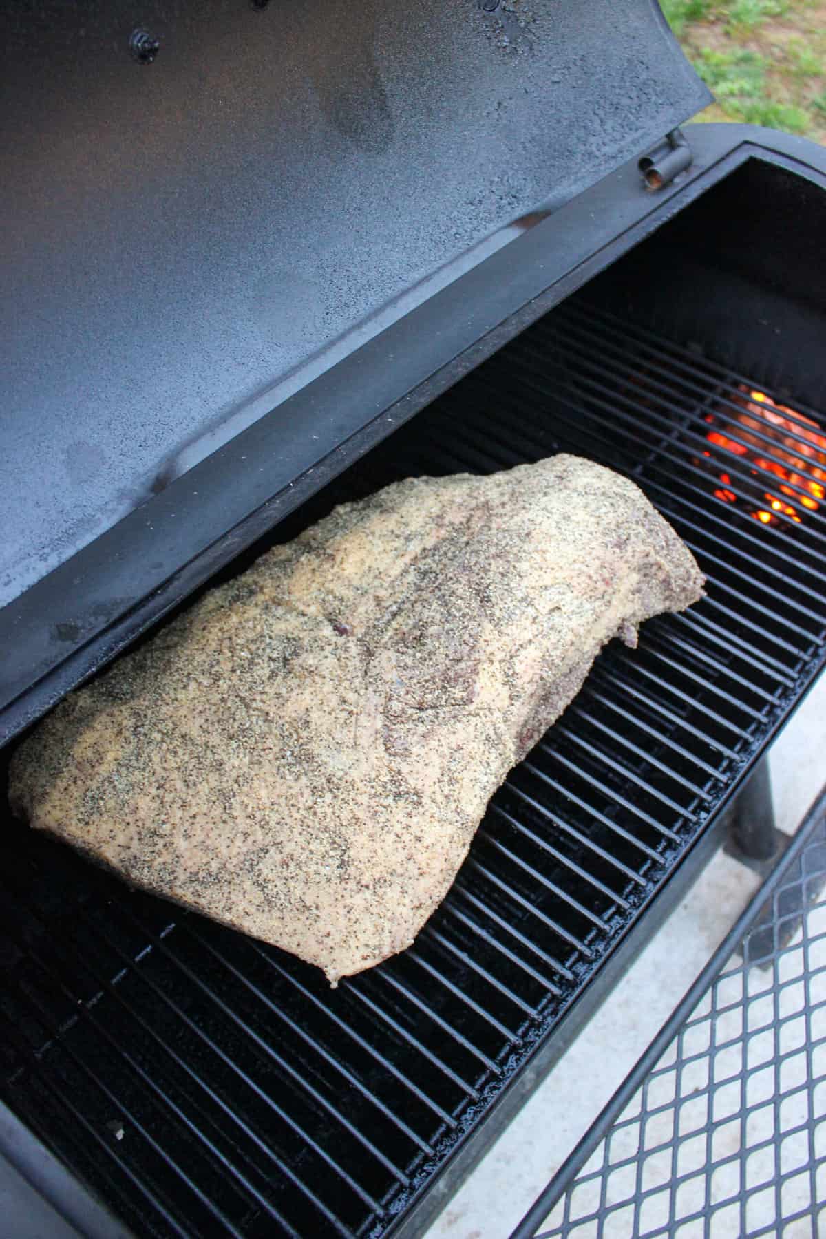 The smoked brisket recipe getting started by placing the seasoned brisket on the smoker.