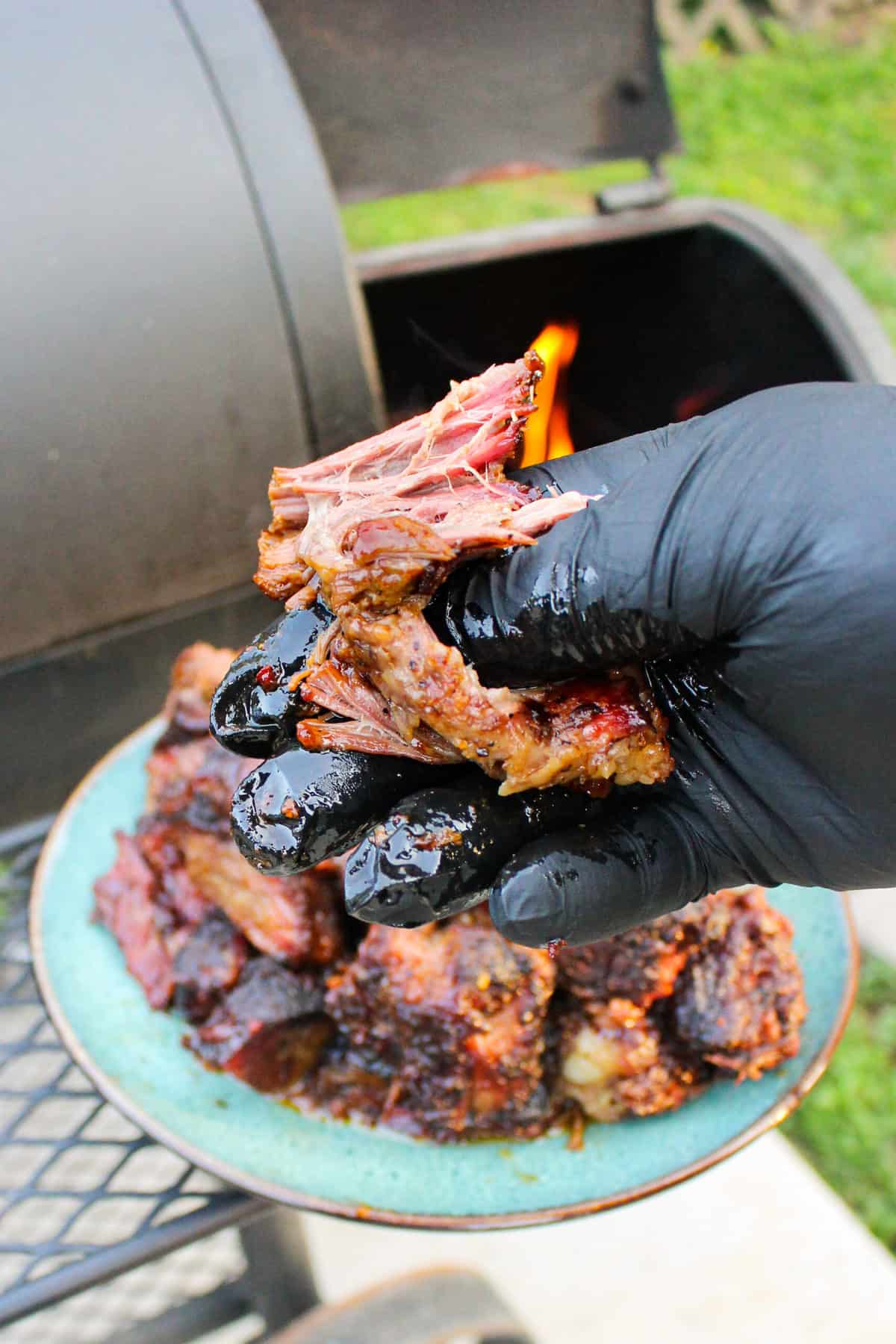 a burnt end being grabbed off of a plate
