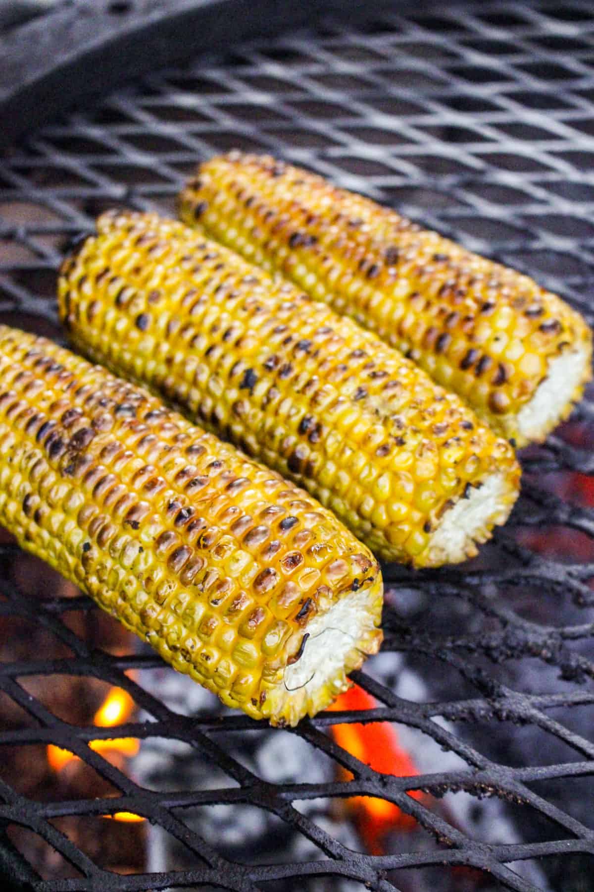 closeup of three charred cobs of corn
