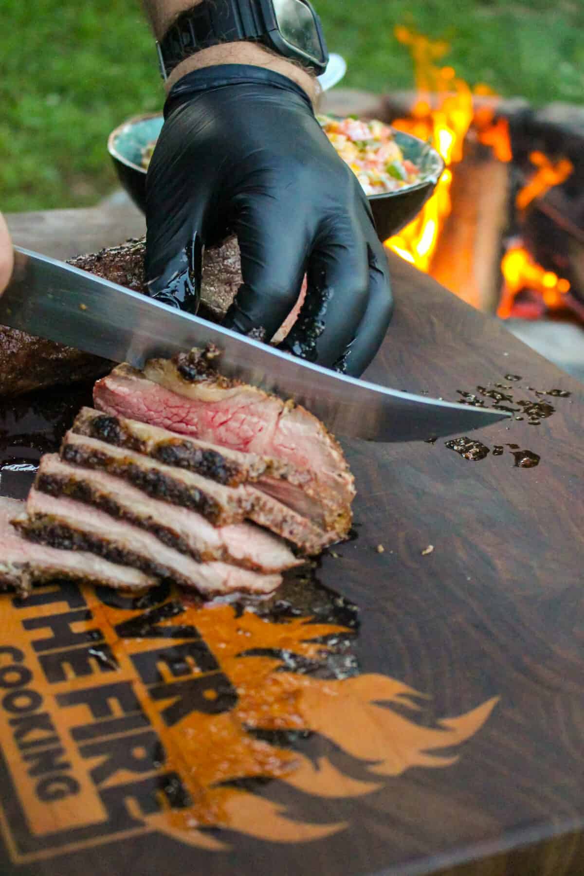 grilled tri-tip being sliced on a cutting board