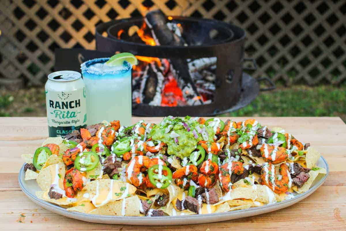 platter full of surf and turf nachos with a margarita in the background
