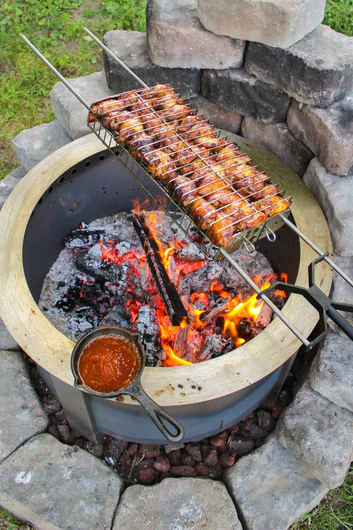 overhead of a rotisserie basket filled with grilled huli huli chicken wings
