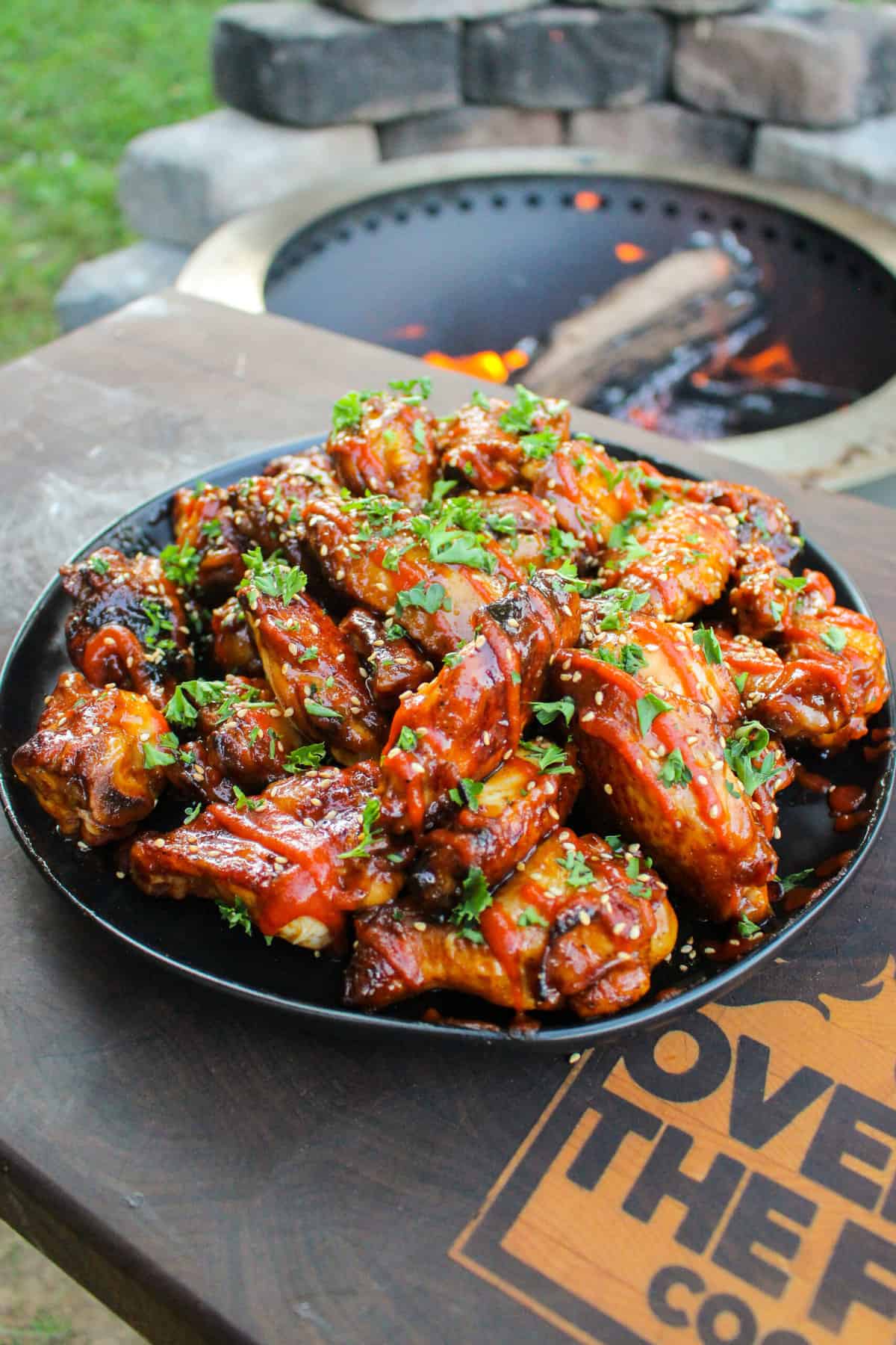 overhead of a pile of chicken wings on a plate sitting on a cutting board