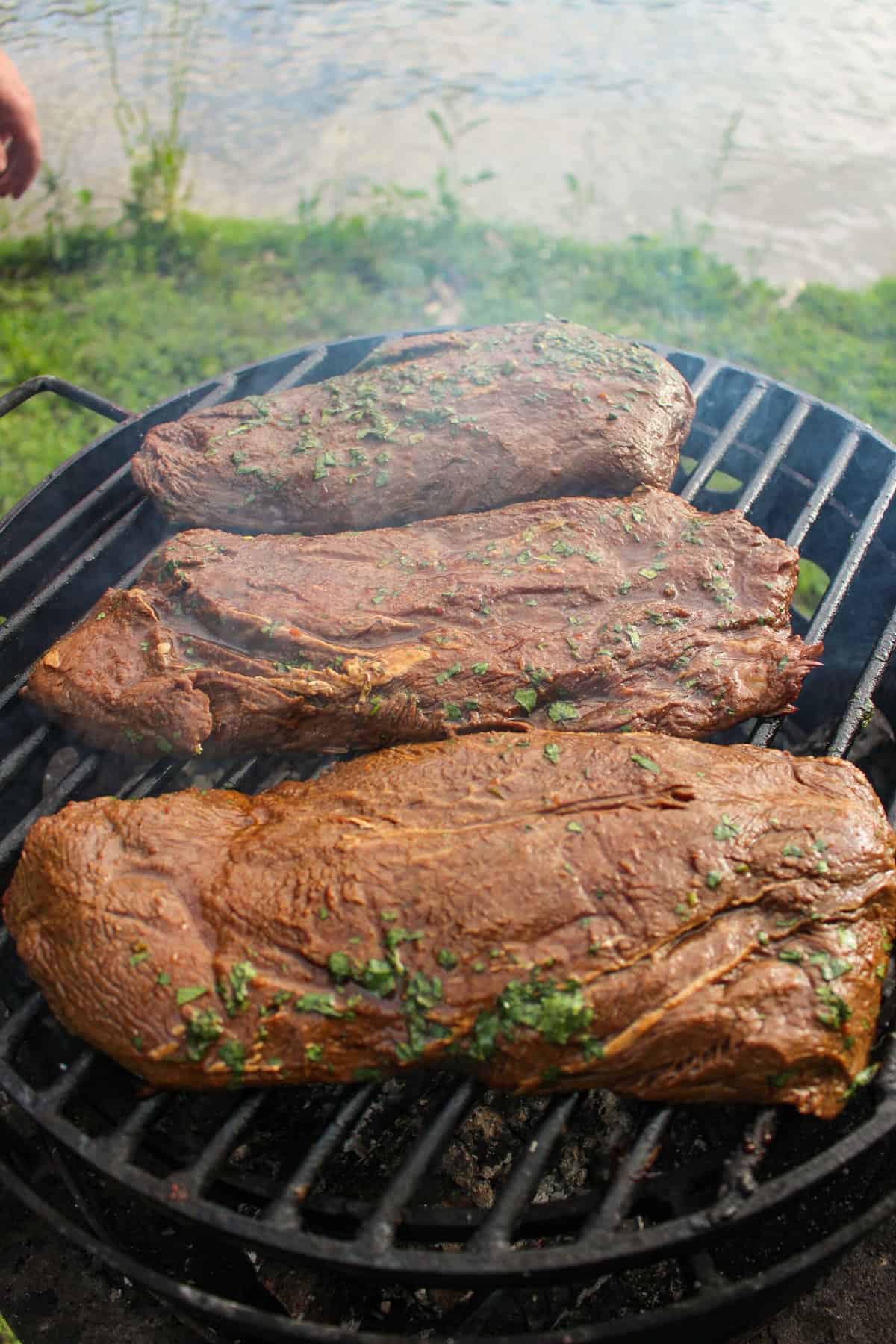 three flat iron steaks on the grill