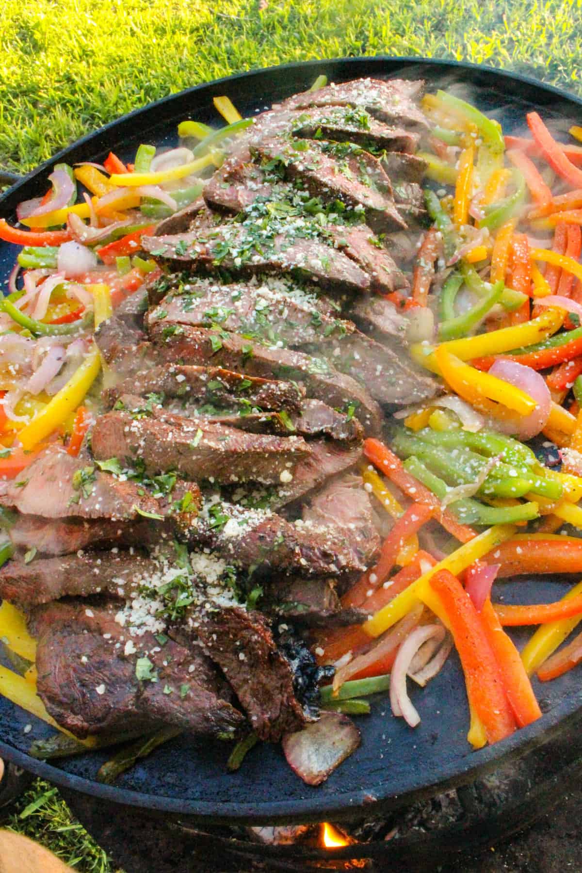 overhead of steak and veggies for Grilled Flat Iron Steak Fajitas on a large plancha