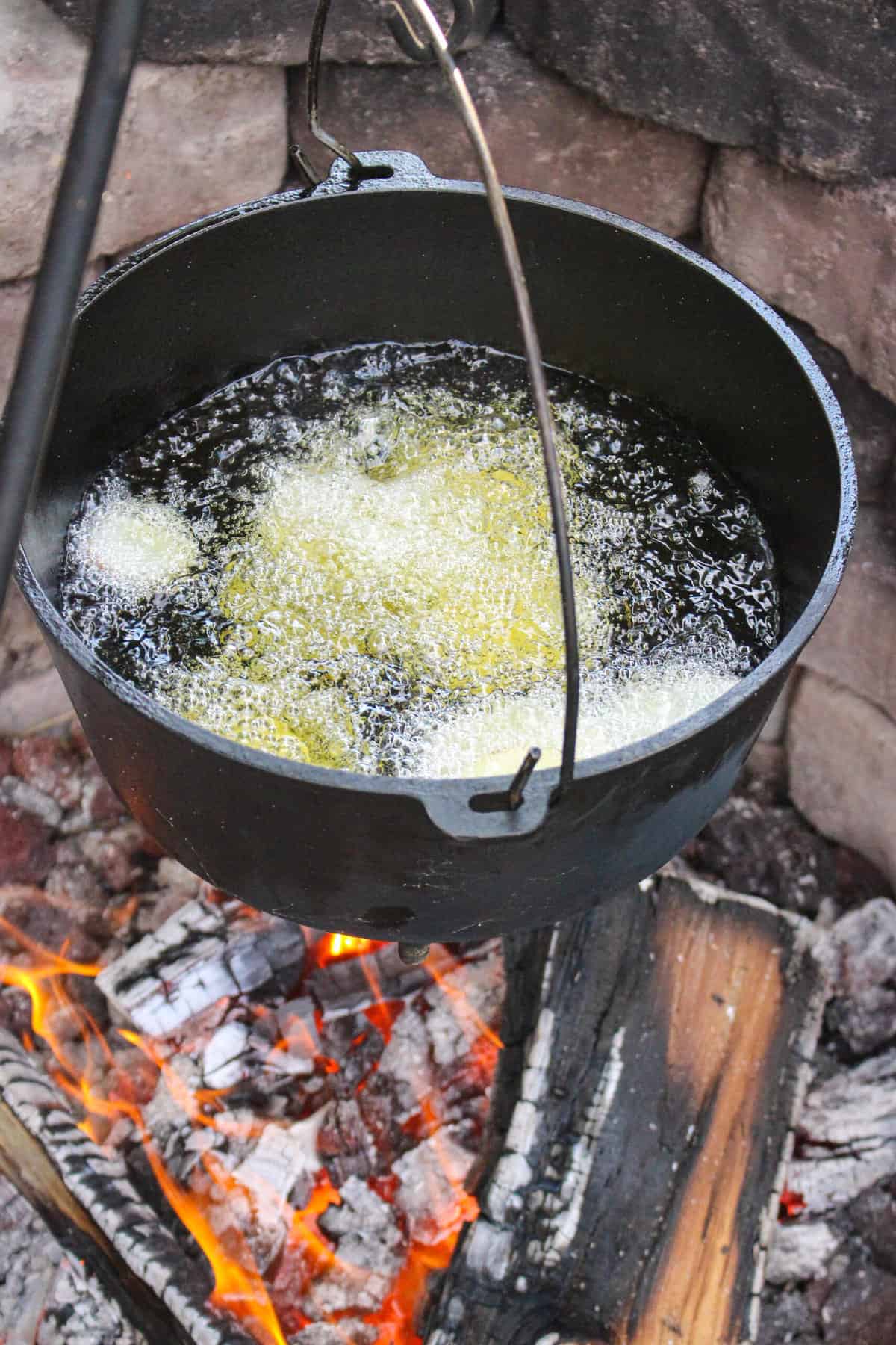 oil heating in a large pot over a fire