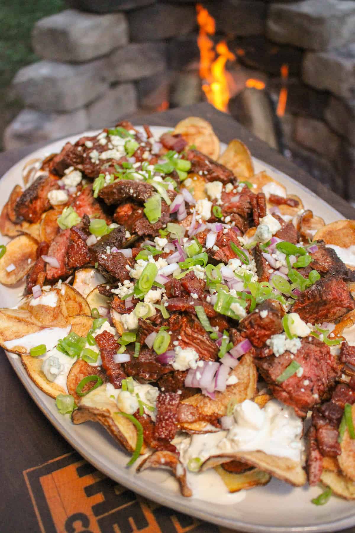 closeup overhead of a pile of loaded kettle chips on a plate over a fire