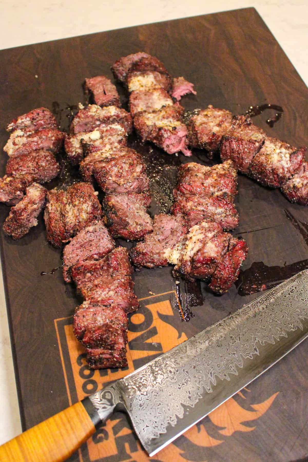 pieces of grilled steak on a cutting board