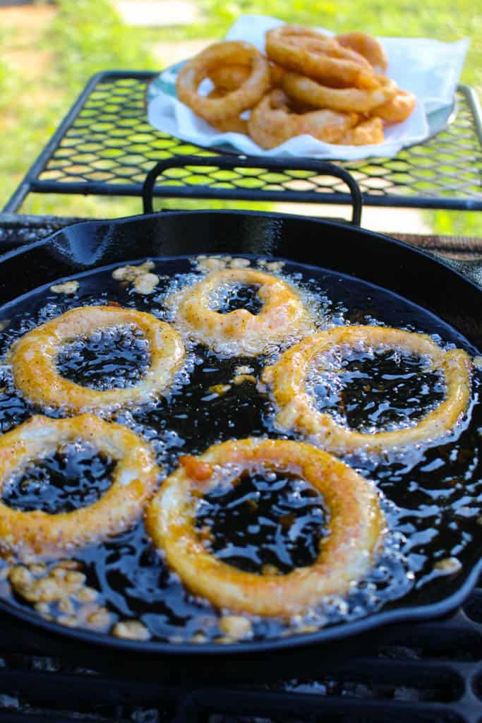 fried onion rings in a skillet of oil
