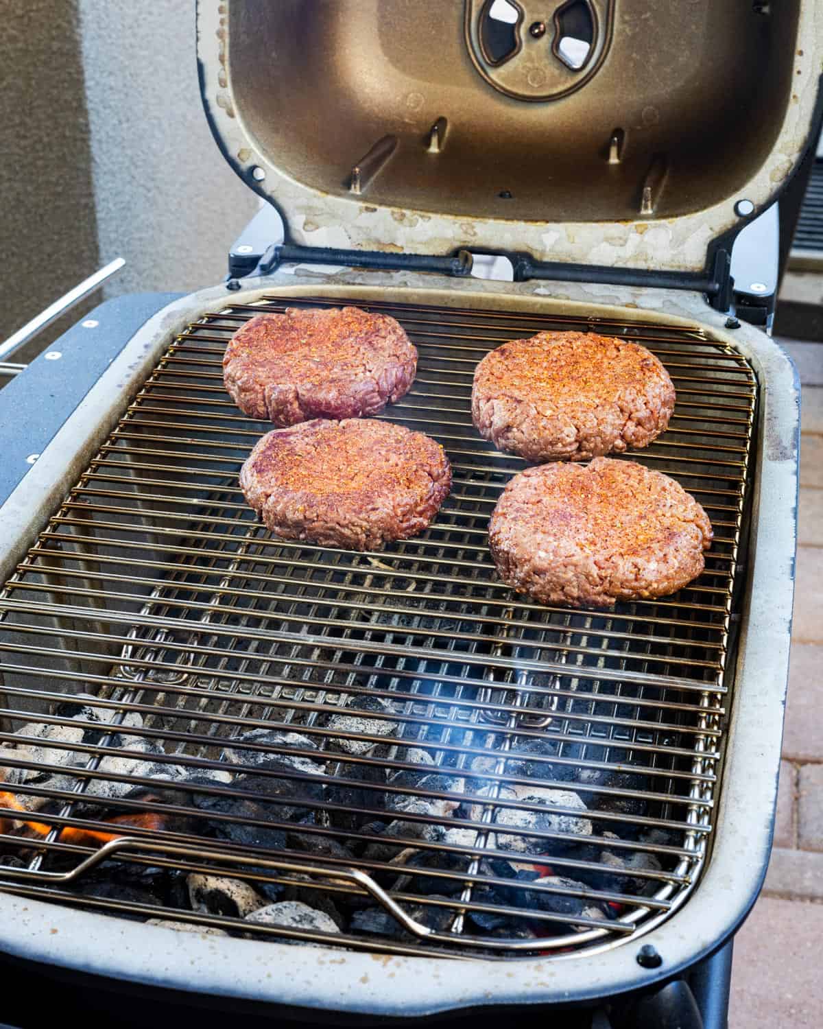 Beef patties hitting the grill. 