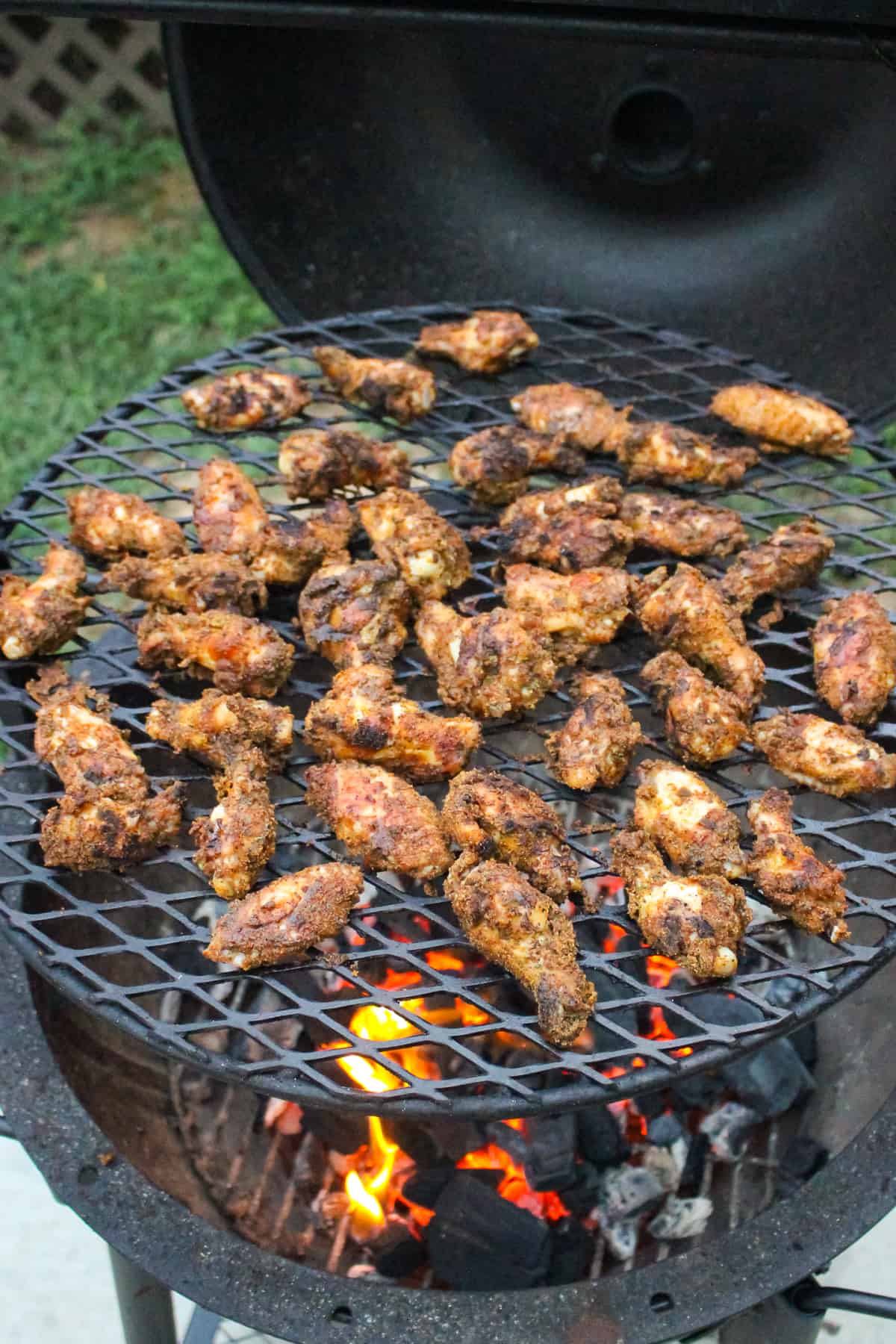 overhead of grilled chicken wings on a grill grate