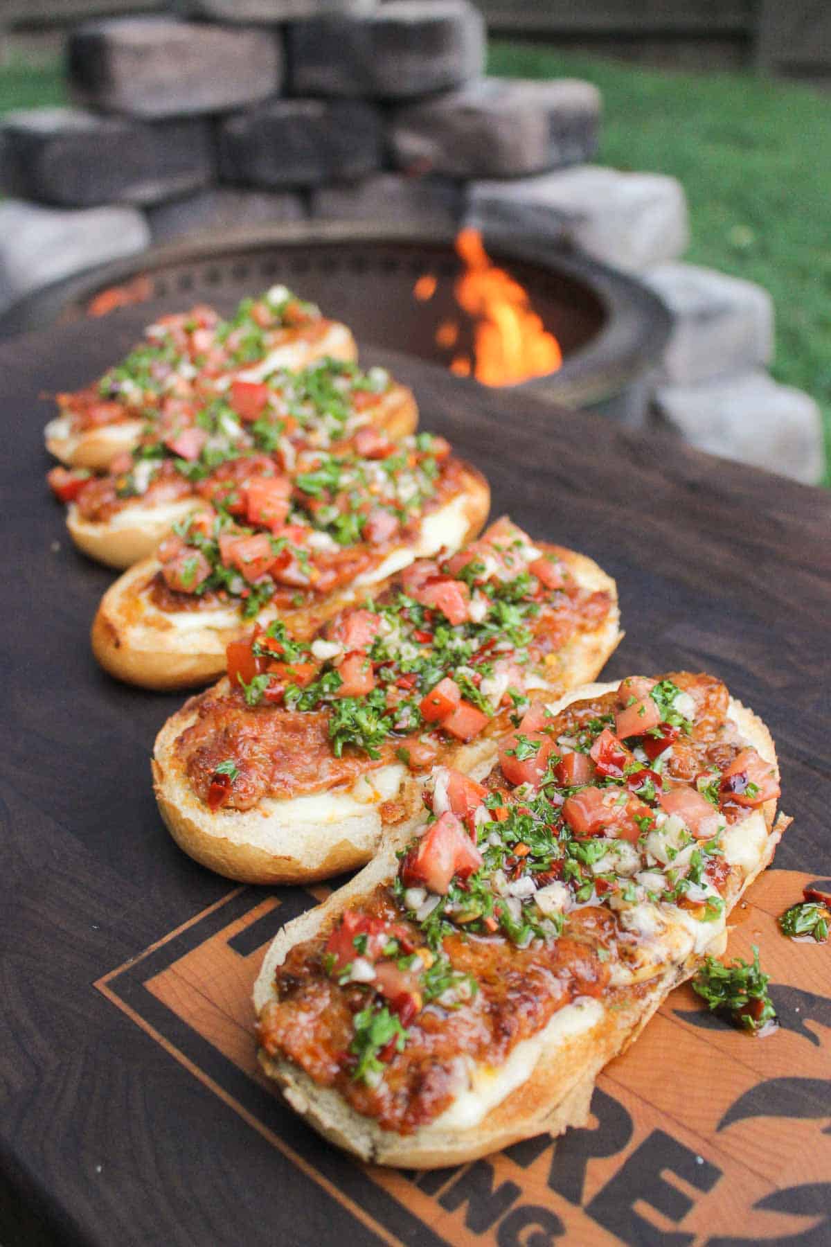 five chorizo covered buns topped with tomato chimichurri
