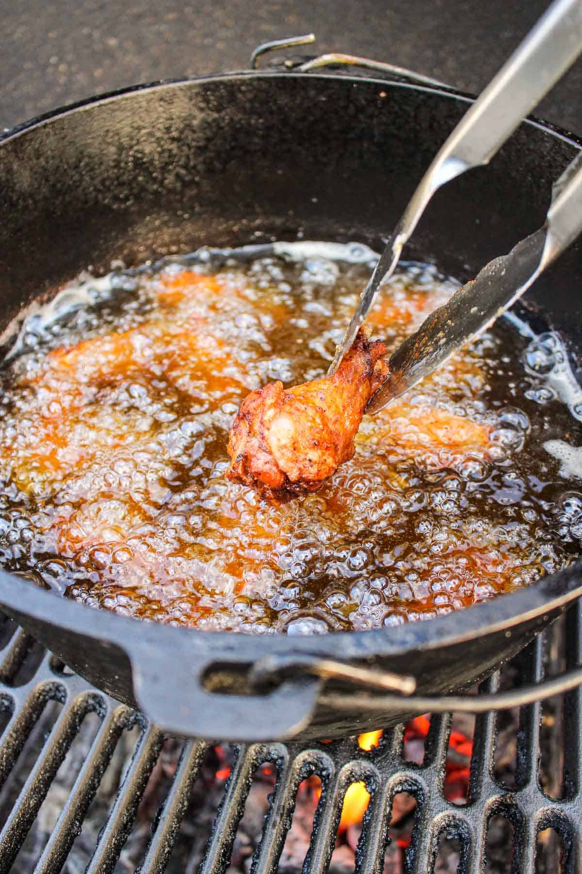 smoked double fried wings being pulled out of a pot of oil