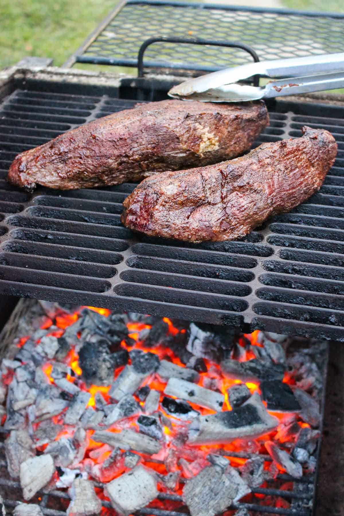 two steaks on a grill from the side