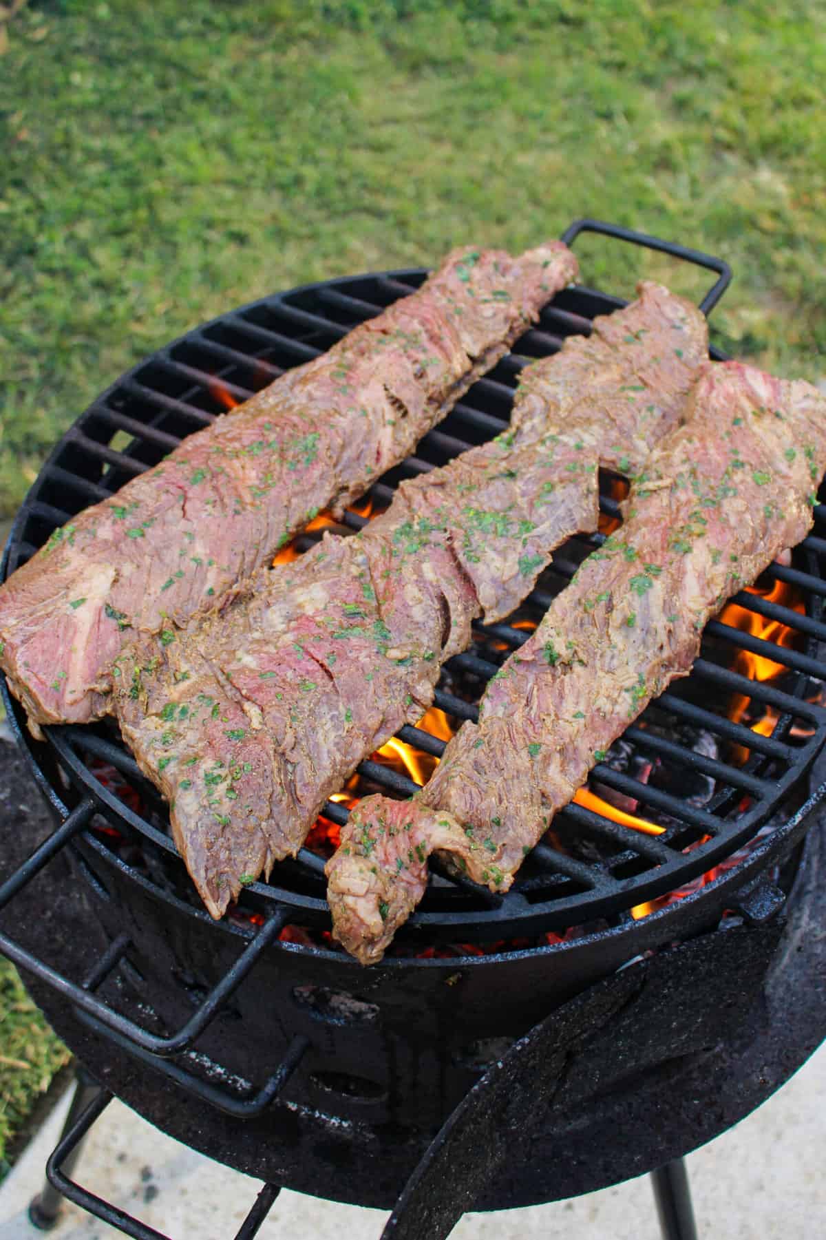 three pieces of steak on a grill