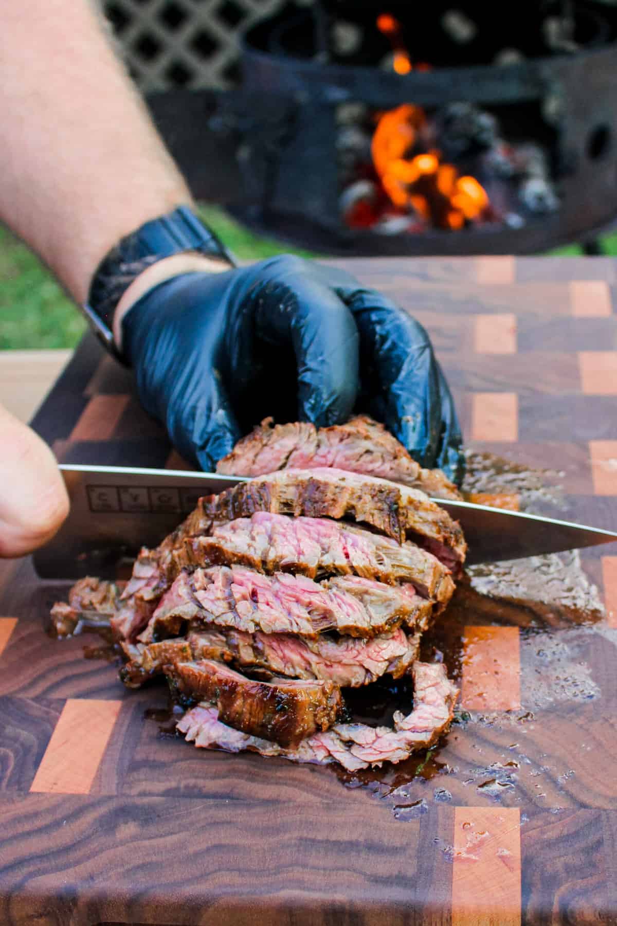 cooked steak being sliced on a cutting board