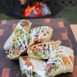 a pile of california burrito halves piled on a cutting board