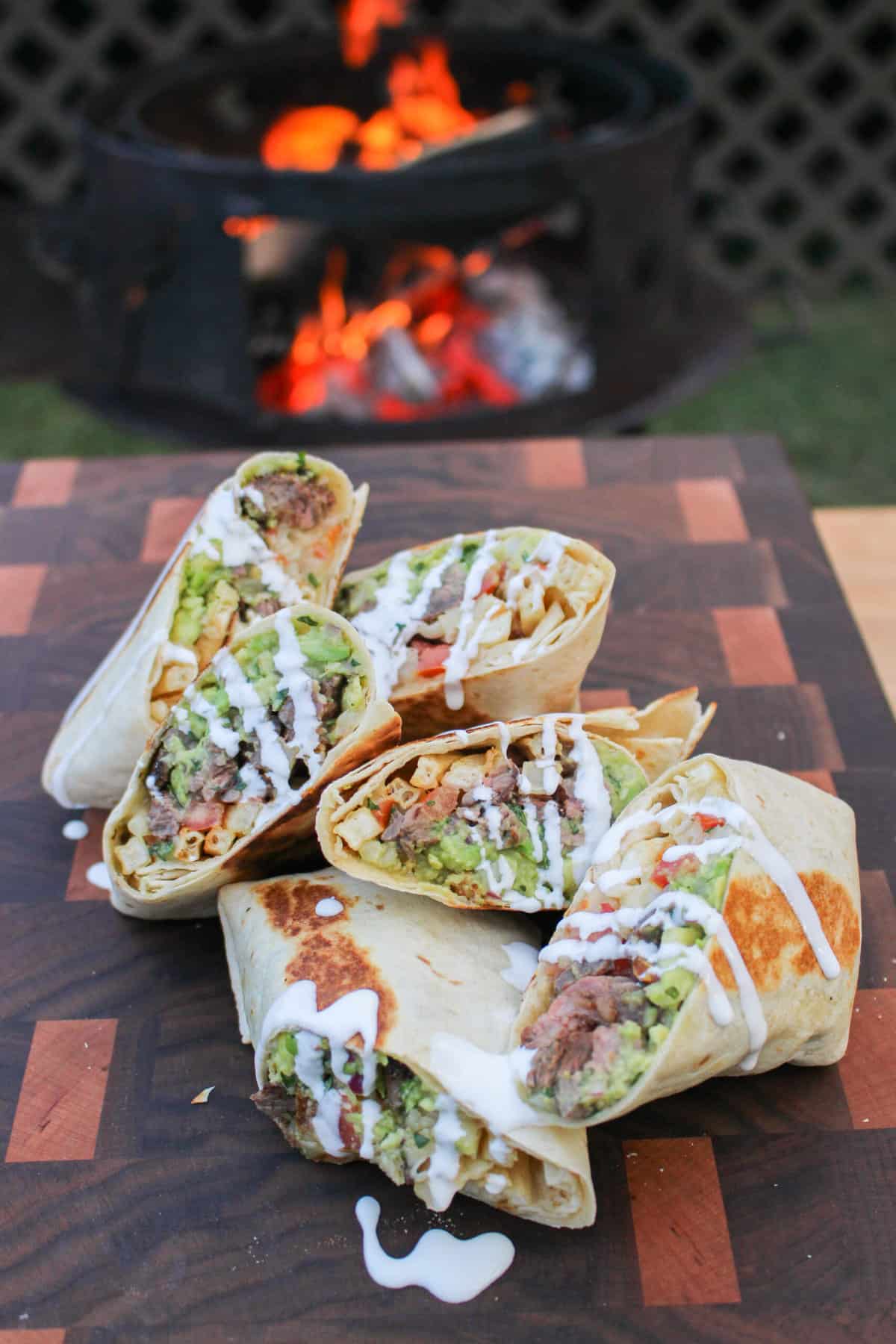 a pile of california burrito halves piled on a cutting board