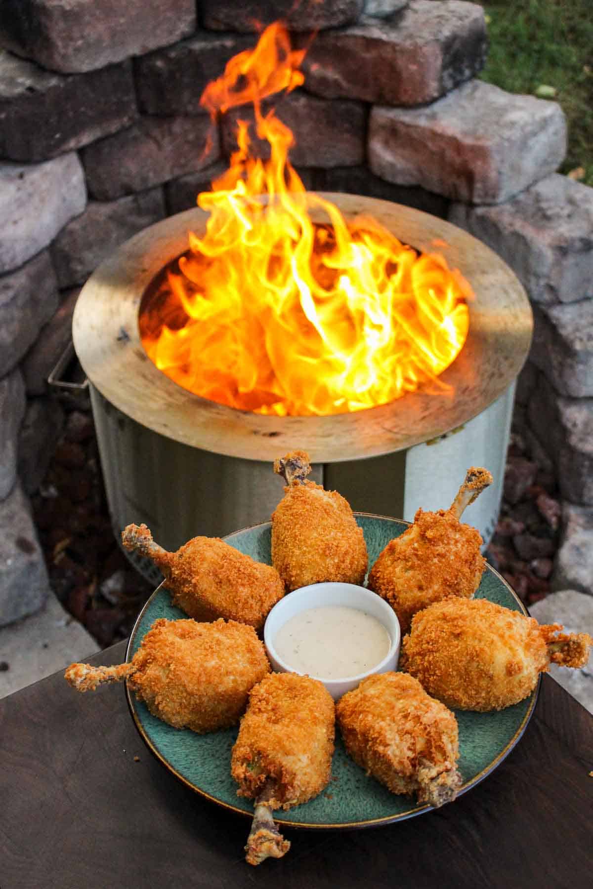 finished fried chicken on a plate in a circle around a dish of ranch