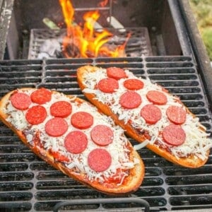 two halves of pepperoni pizza on a grill