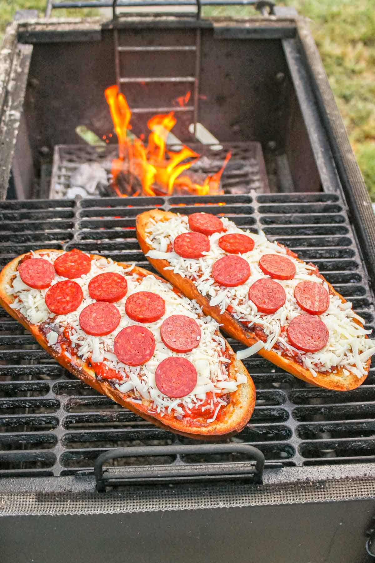 two halves of pepperoni pizza on a grill