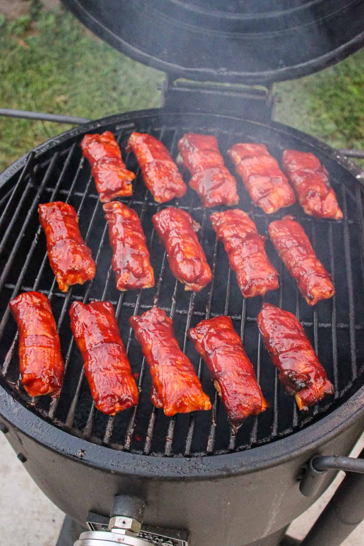 cooked bacon wrapped manicotti lined on a smoker