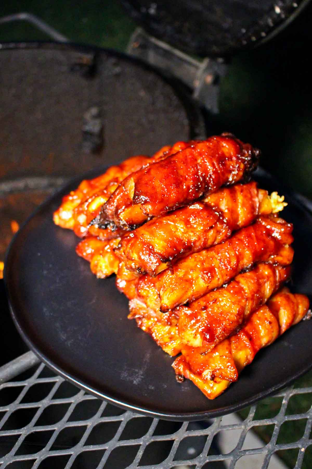 bacon wrapped stuffed manicotti stacked on a plate