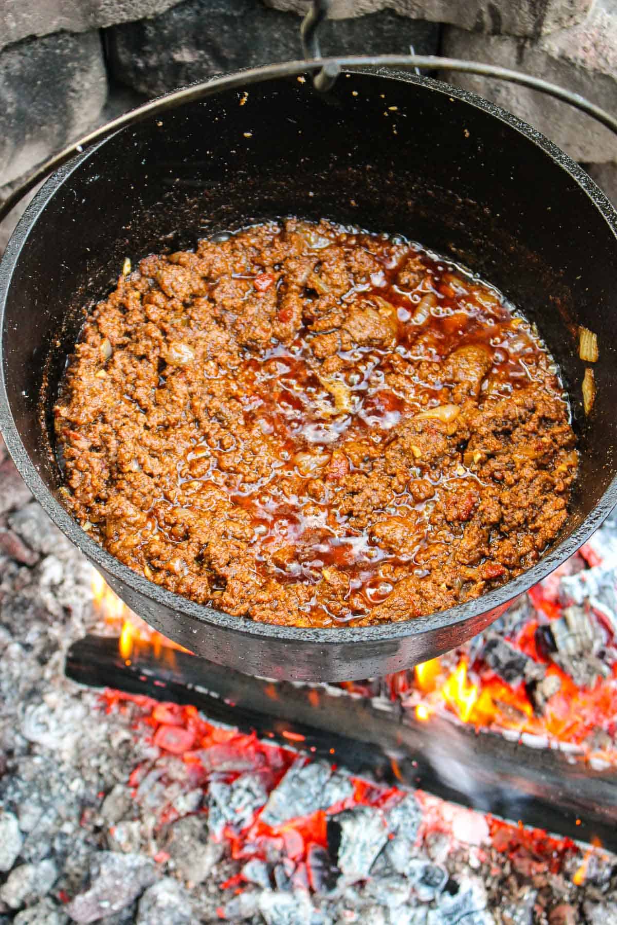 chili in a large dutch oven over a fire